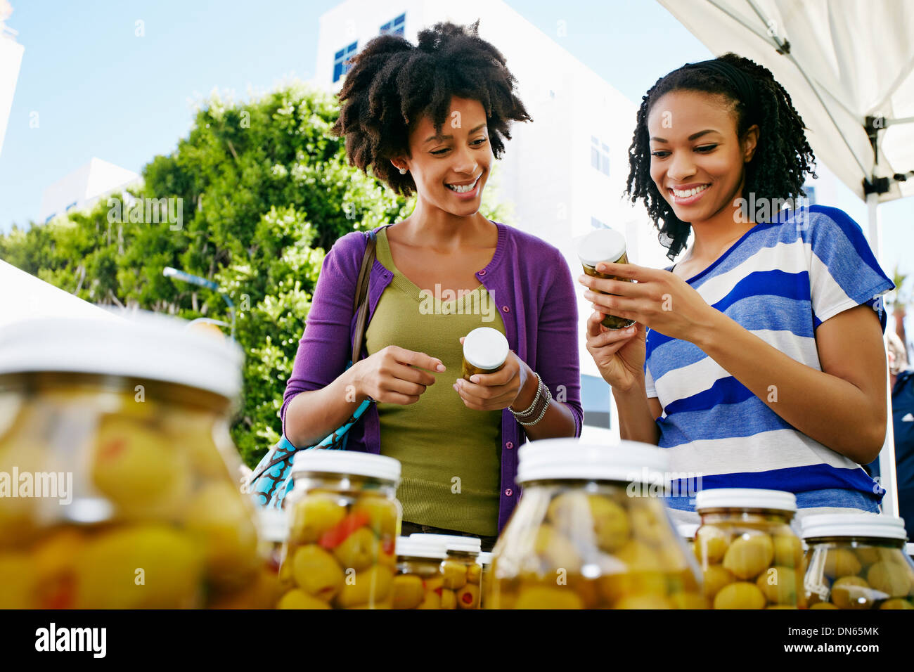 Women smiling together at outdoor market Banque D'Images