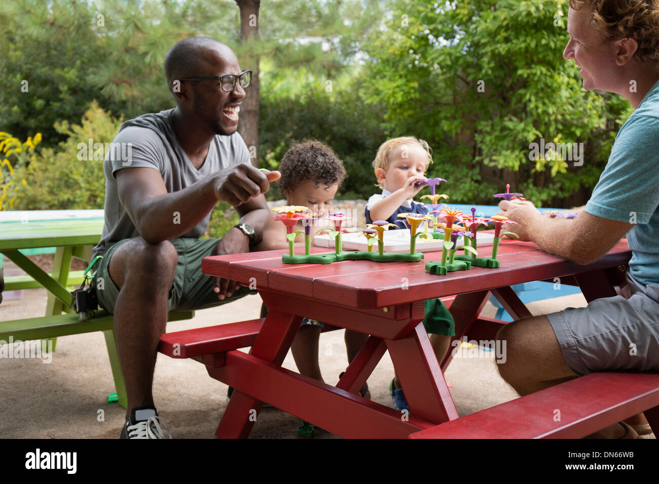 Pères et fils tout-petits à jouer à une table de pique-nique Banque D'Images