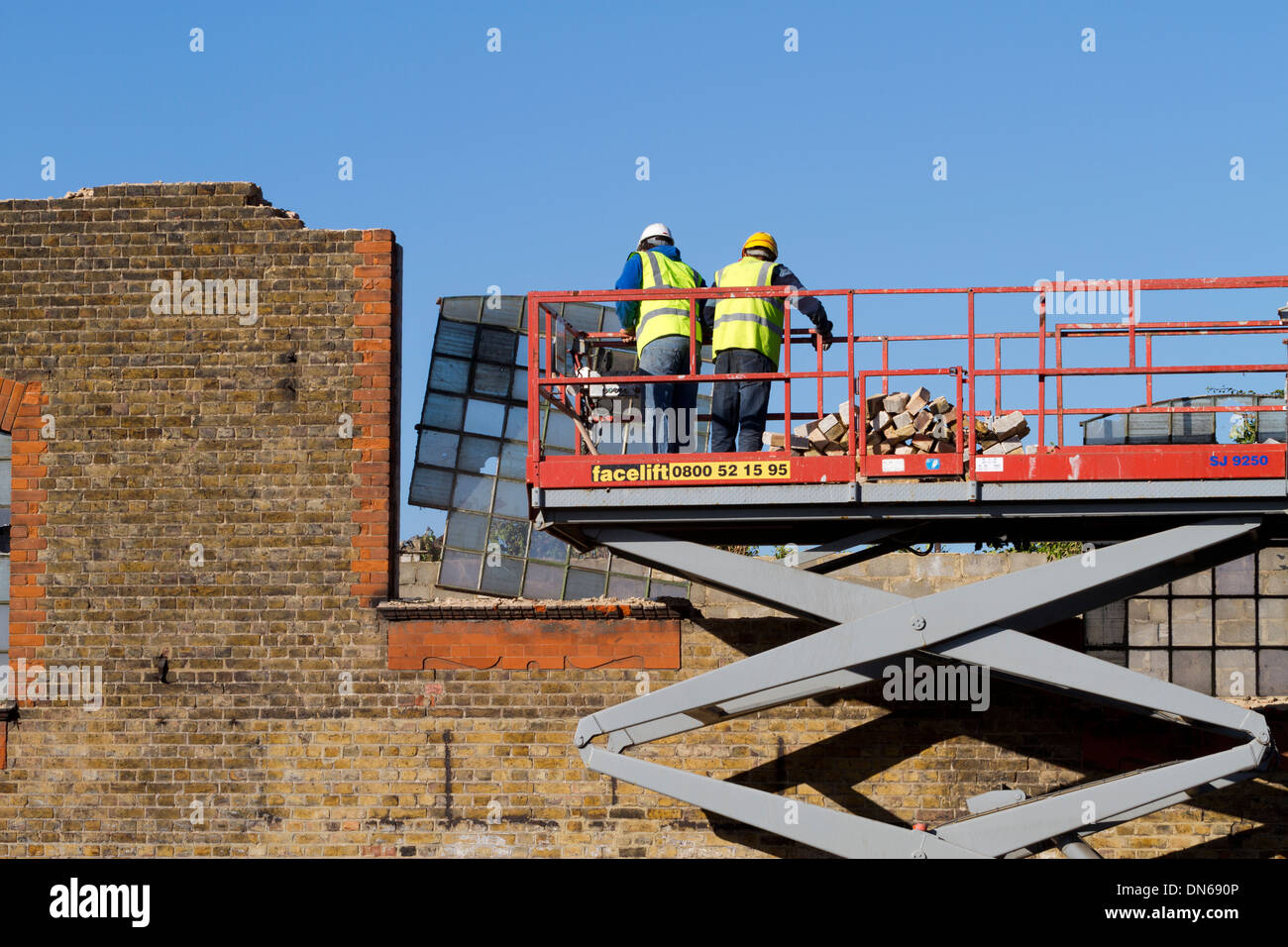 Les travailleurs du chantier de démolition démantèlement d'une centrale électrique de la fin de l'époque victorienne à Twickenham, London, UK. Banque D'Images
