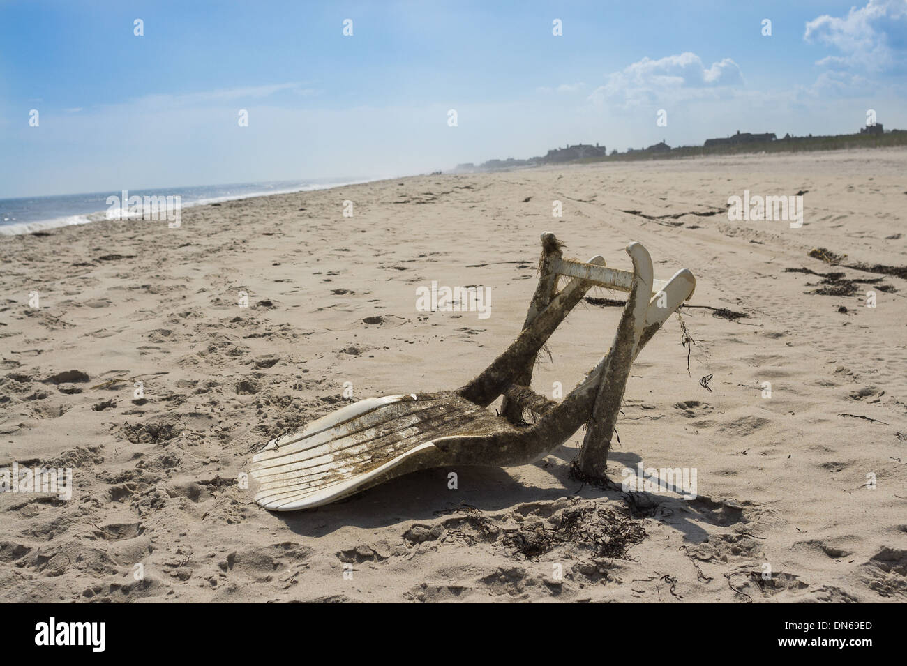 Chaise de jardin en plastique porté par la marée de la rive, la preuve de la pollution dans la mer Banque D'Images