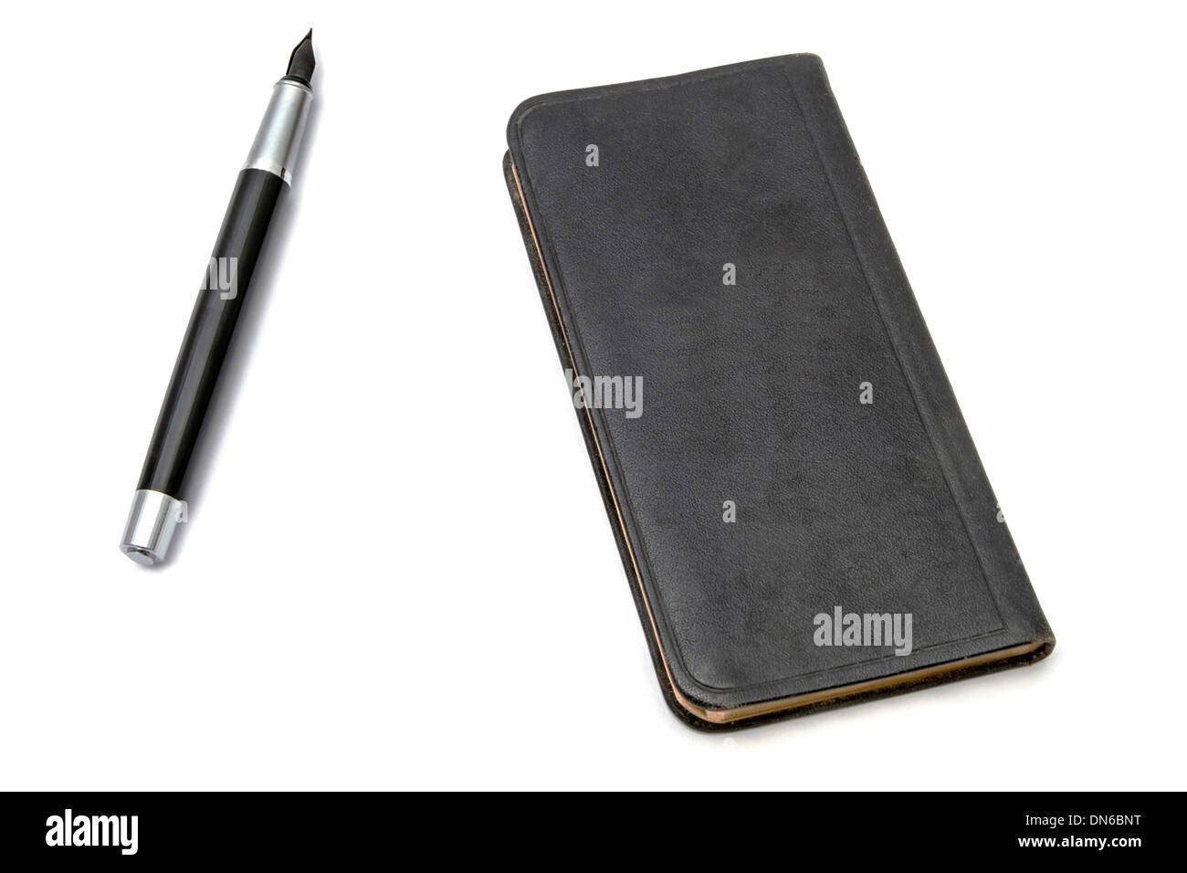 Livre noir et stylo gros plan sur fond blanc Banque D'Images