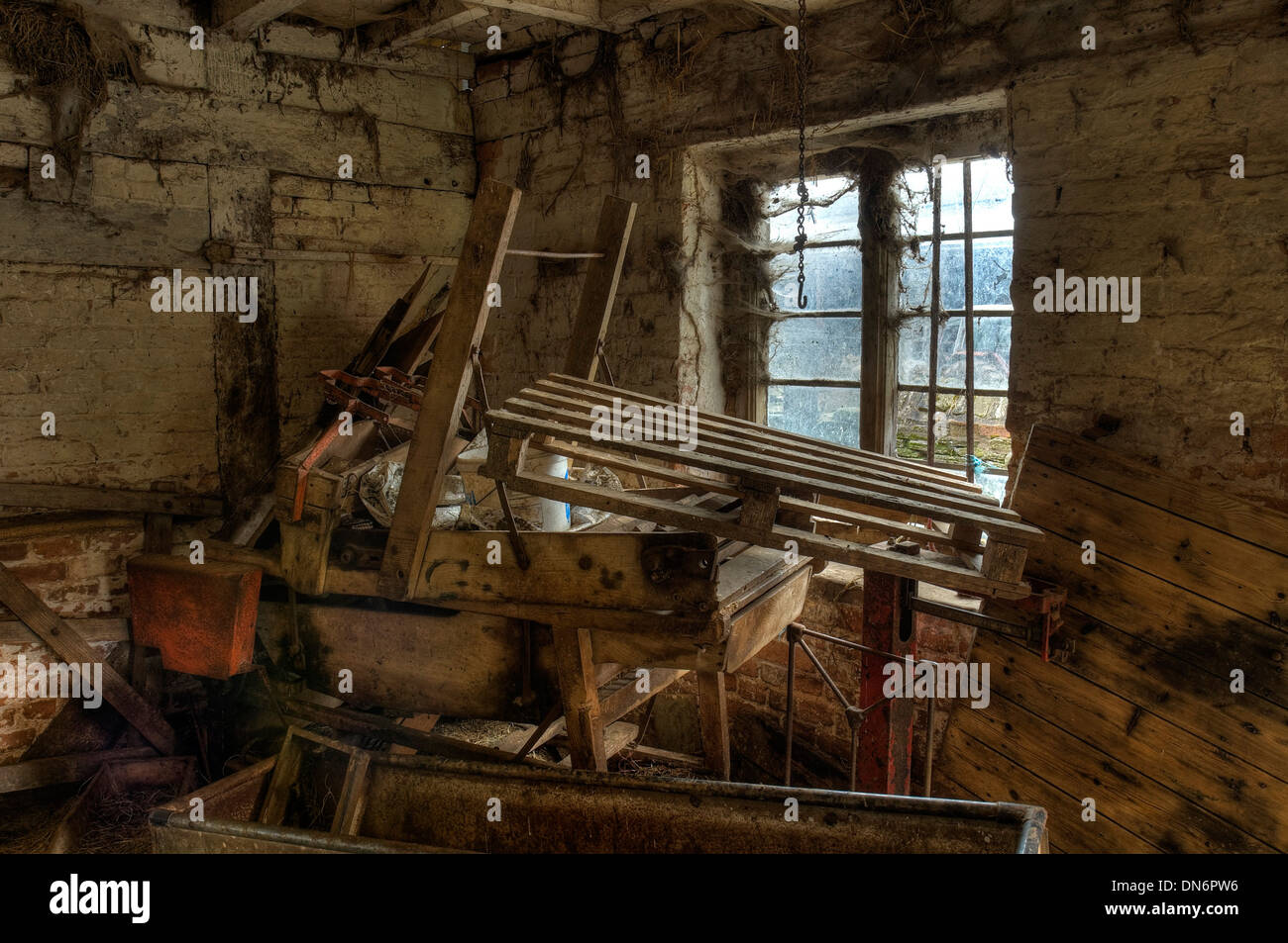 Old farm machinery empilées dans le coin d'un cowhouse, Worcestershire, Angleterre. Banque D'Images