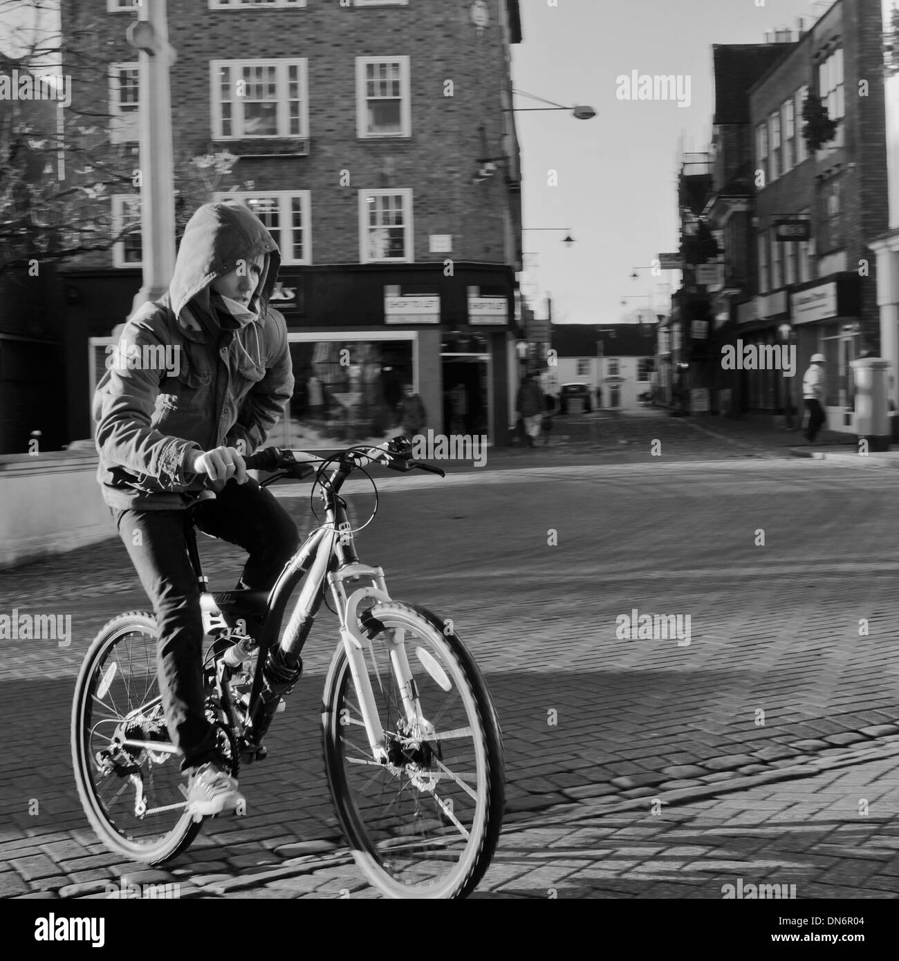 Adolescent avec le capot du vélo dans le centre ville, Aylesbury, Buckinghamshire, Angleterre Banque D'Images