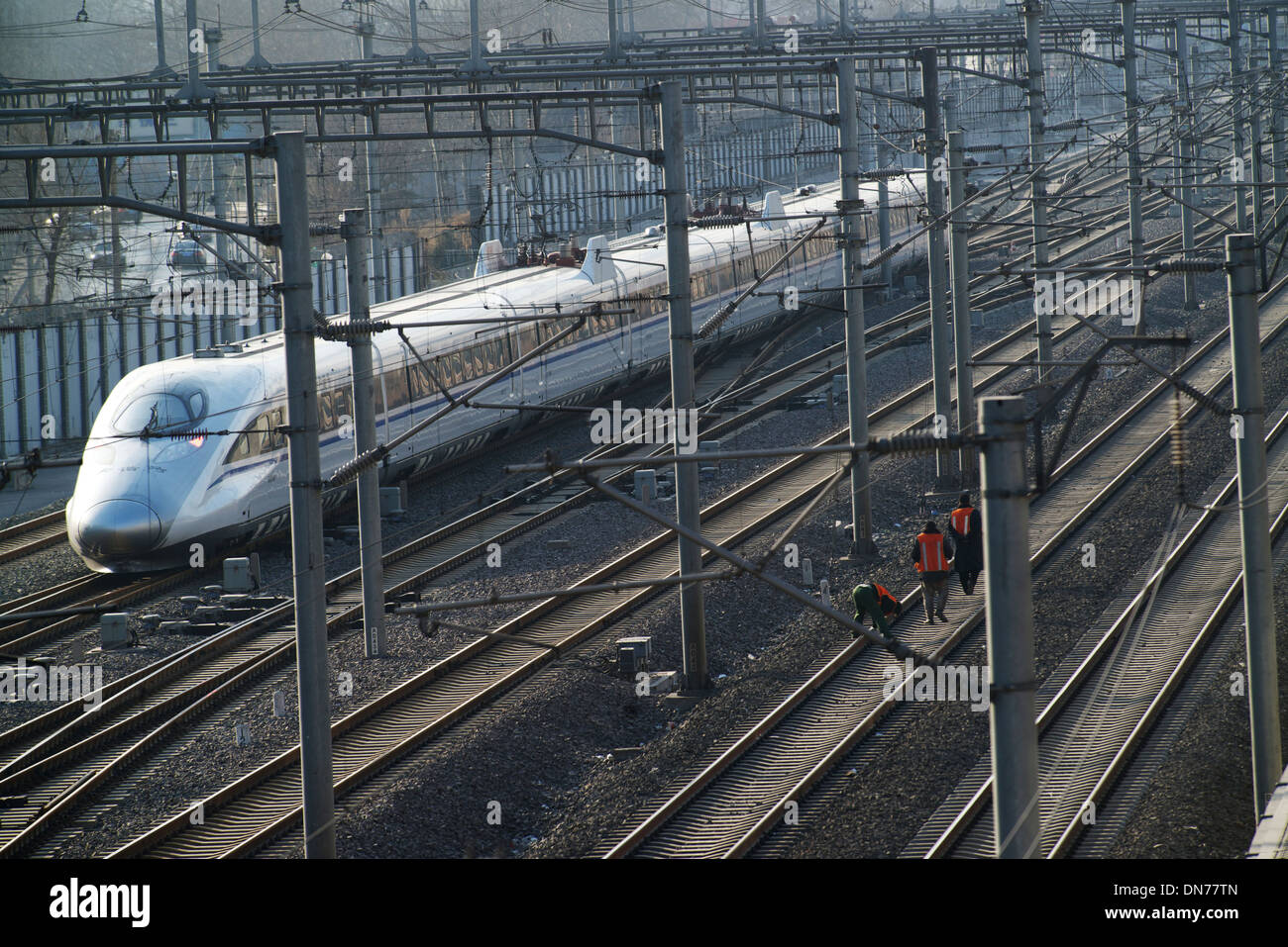 Vérifier les marcheurs de la voie voie tandis qu'un train à grande vitesse va passer en gare sud de Beijing, à Beijing, en Chine. 15-Déc-2013 Banque D'Images