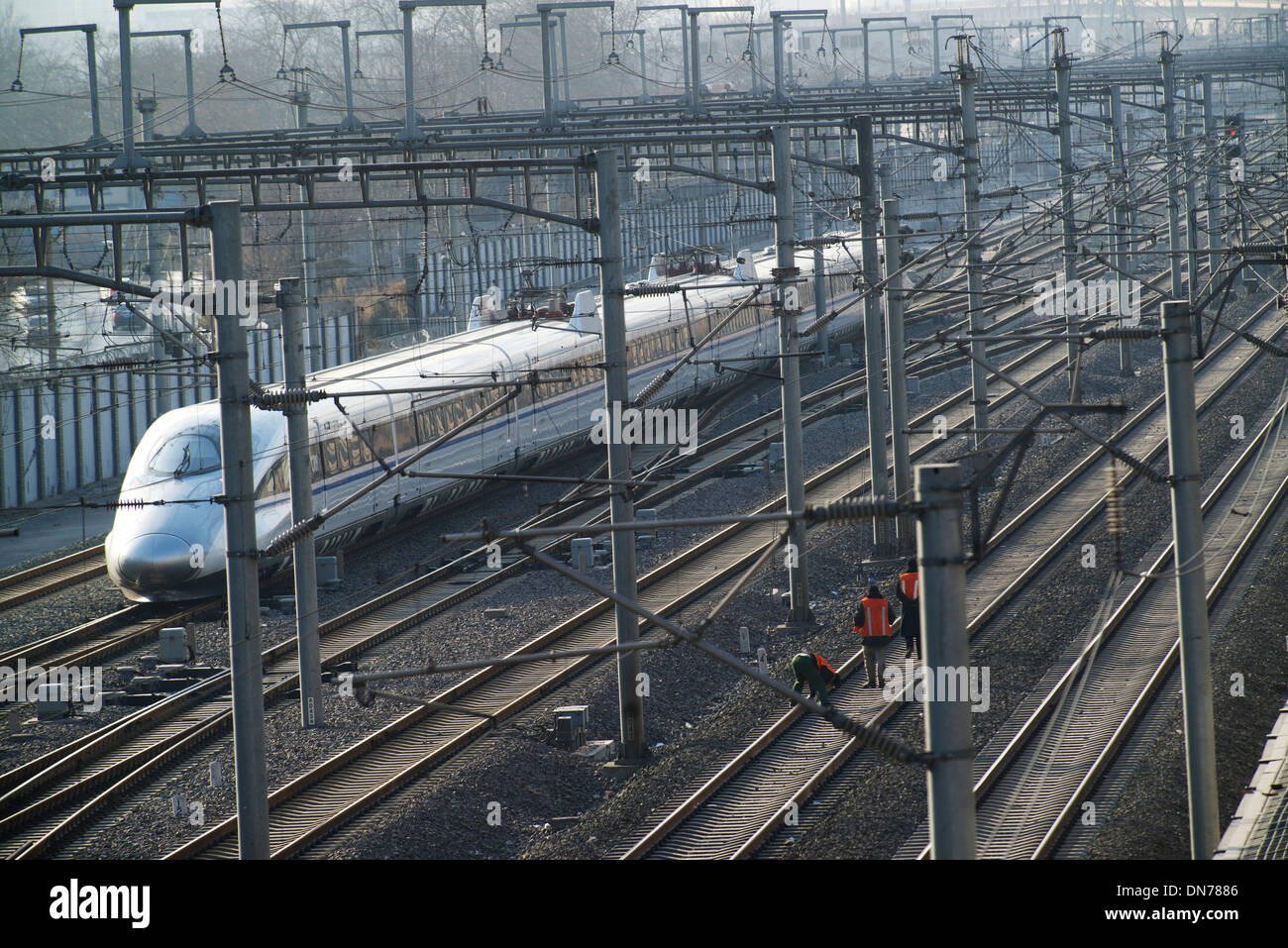 Vérifier les marcheurs de la voie voie tandis qu'un train à grande vitesse va passer en gare sud de Beijing, à Beijing, en Chine. 15-Déc-2013 Banque D'Images