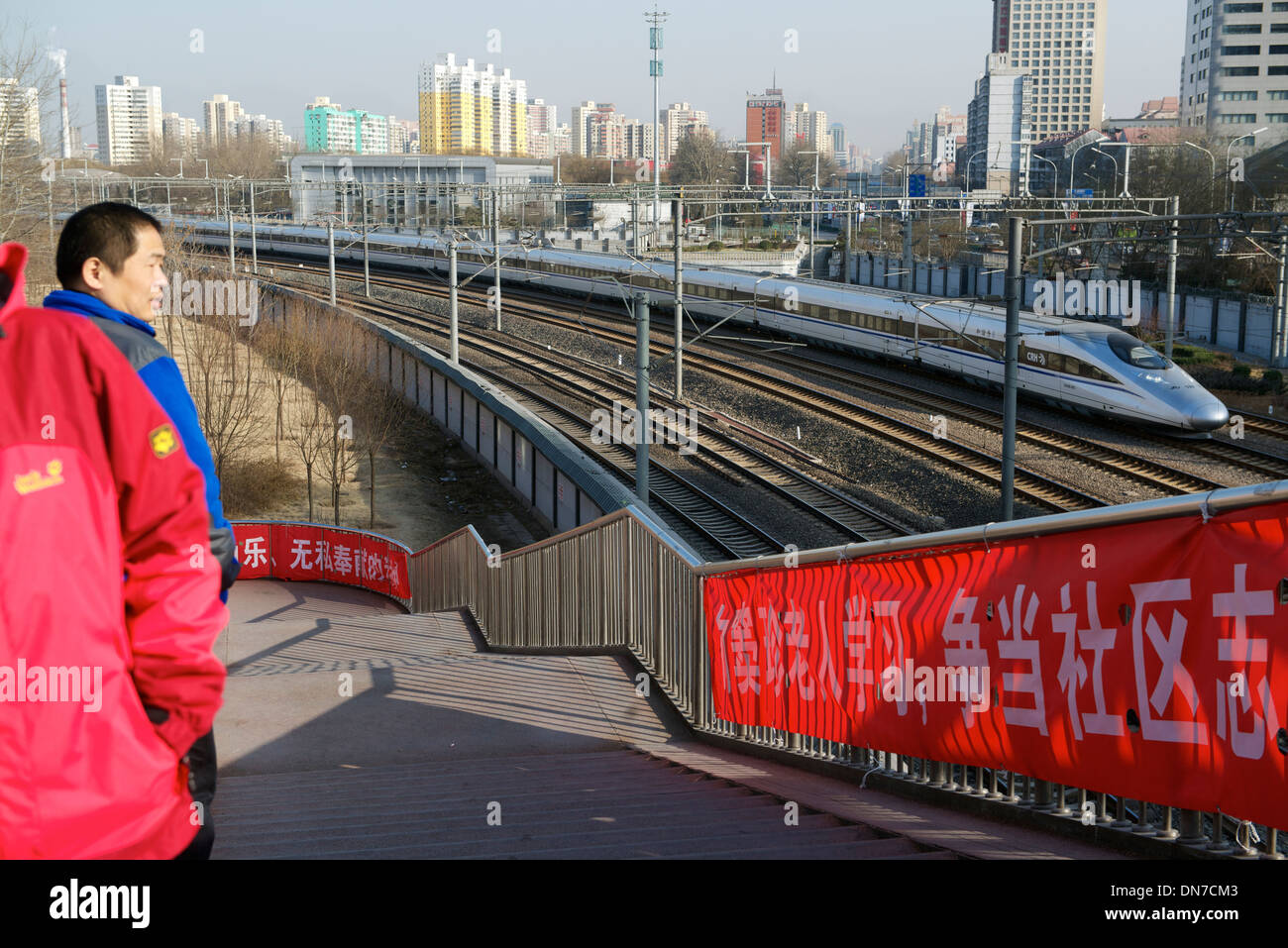 On marche sur une passerelle alors qu'un train à grande vitesse quitte Beijing south station à Beijing, Chine. 15-Déc-2013 Banque D'Images