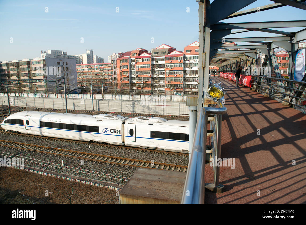 On marche sur une passerelle alors qu'un train à grande vitesse va passer en gare sud de Beijing, à Beijing, en Chine. 15-Déc-2013 Banque D'Images