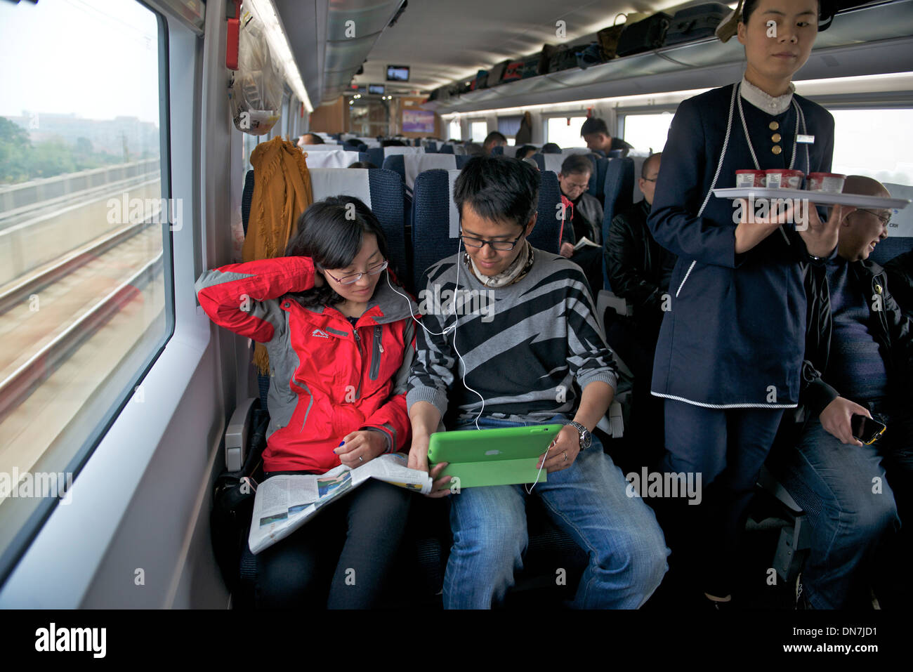 Chen Fei et Han Jiale couple voir un film ensemble avec un iPad sur un train CRH de Changsha à Shanghai en Chine. 08-Déc-2013 Banque D'Images