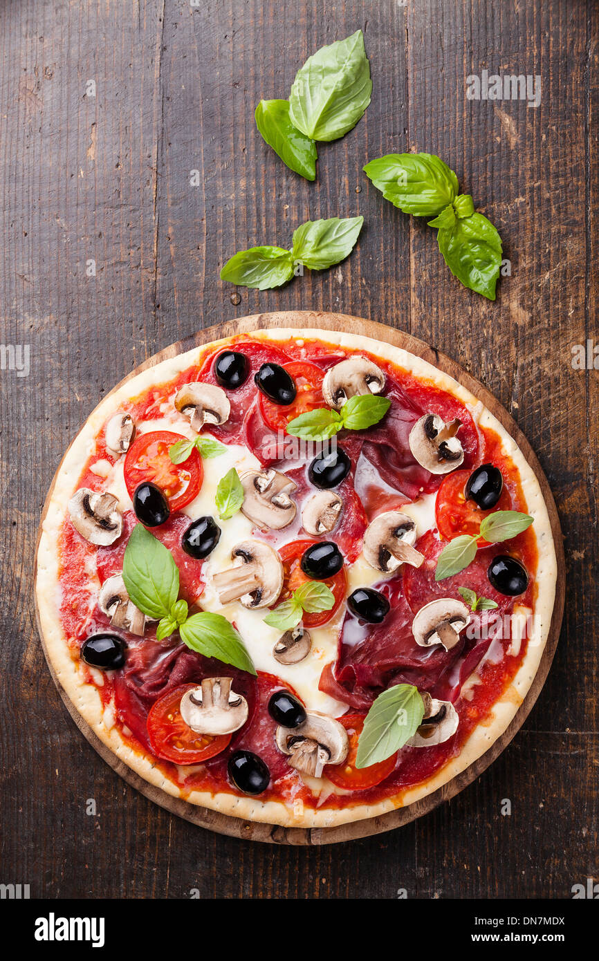 Italian Pizza au salami, les champignons et les olives sur la table en bois Banque D'Images