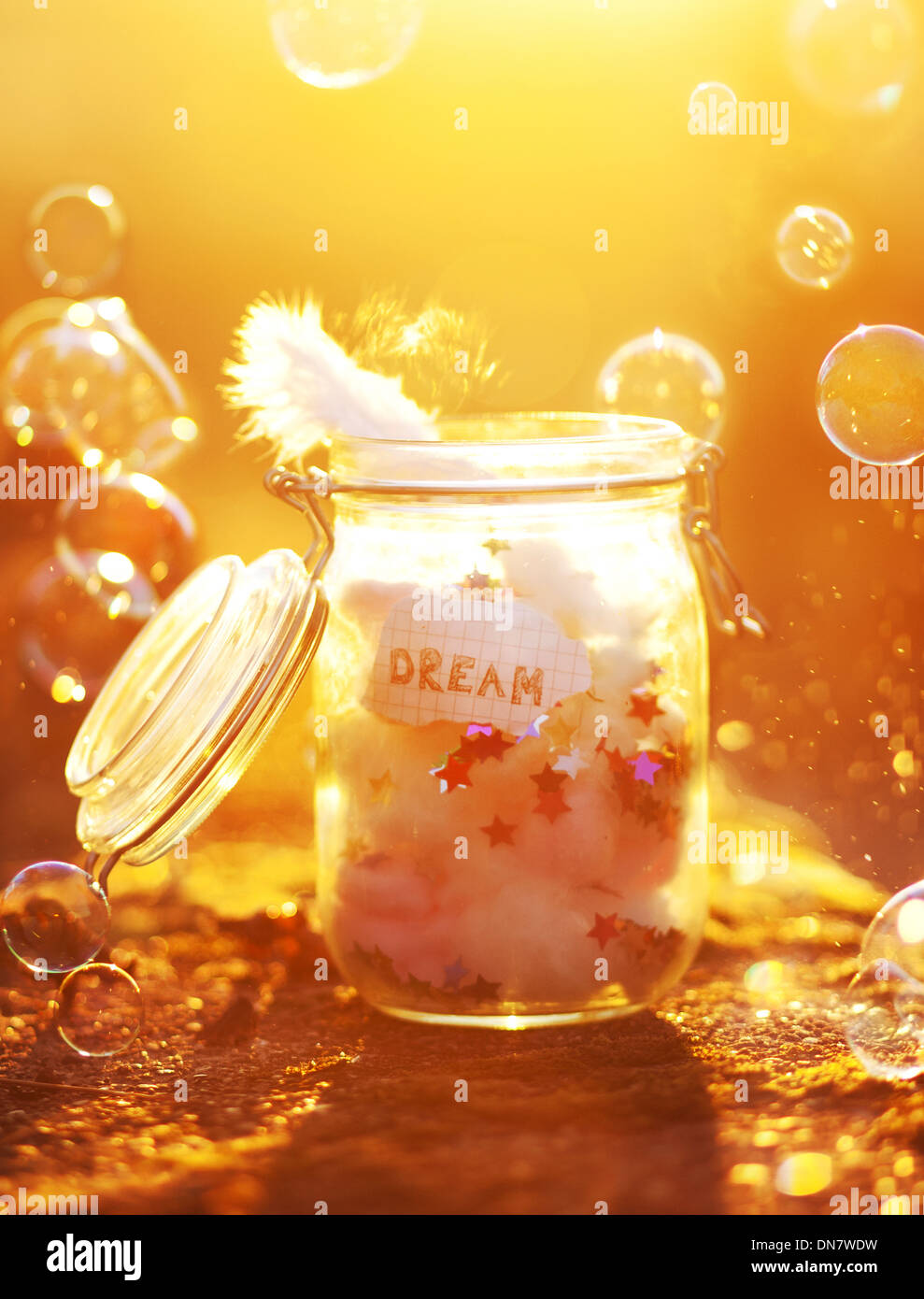 Bocal avec du papier, des plumes et des bulles dans le rétro-éclairage Banque D'Images Bocal avec du papier, des plumes et des bulles dans le rétro-éclairage Banque D'Images