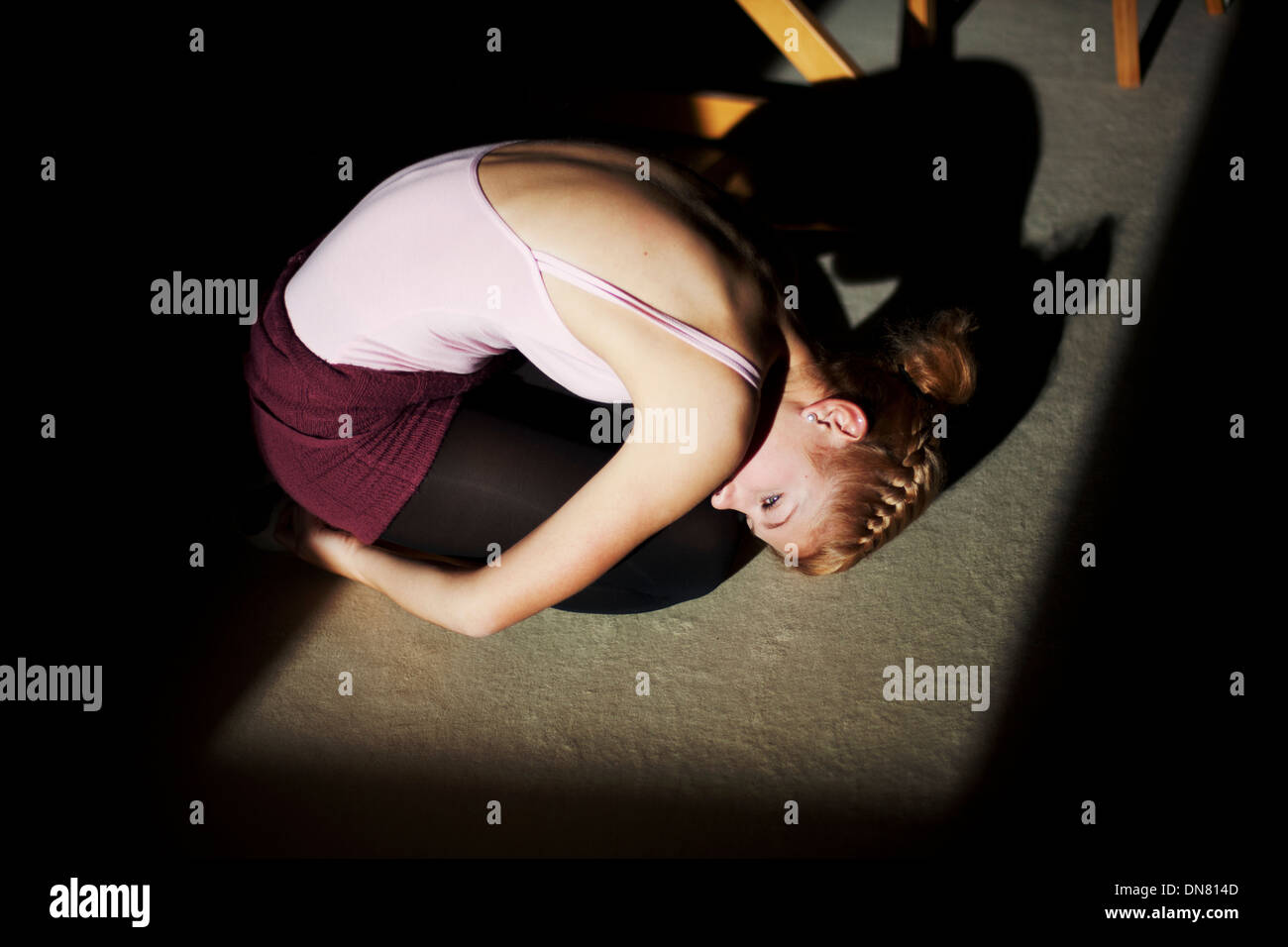 Jeune femme à genoux sur le sol, portrait Banque D'Images