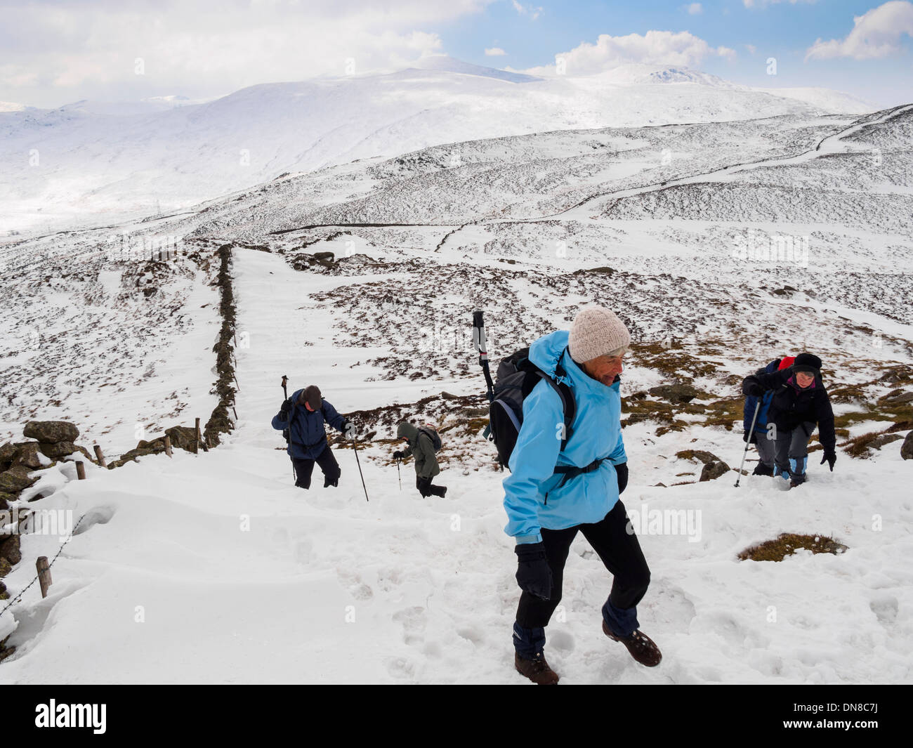 Groupe de Randonneurs marchant Tal-y-Fan mountain dans la neige profonde dans les montagnes du Parc National de Snowdonia, Conwy, Nord du Pays de Galles, Royaume-Uni Banque D'Images