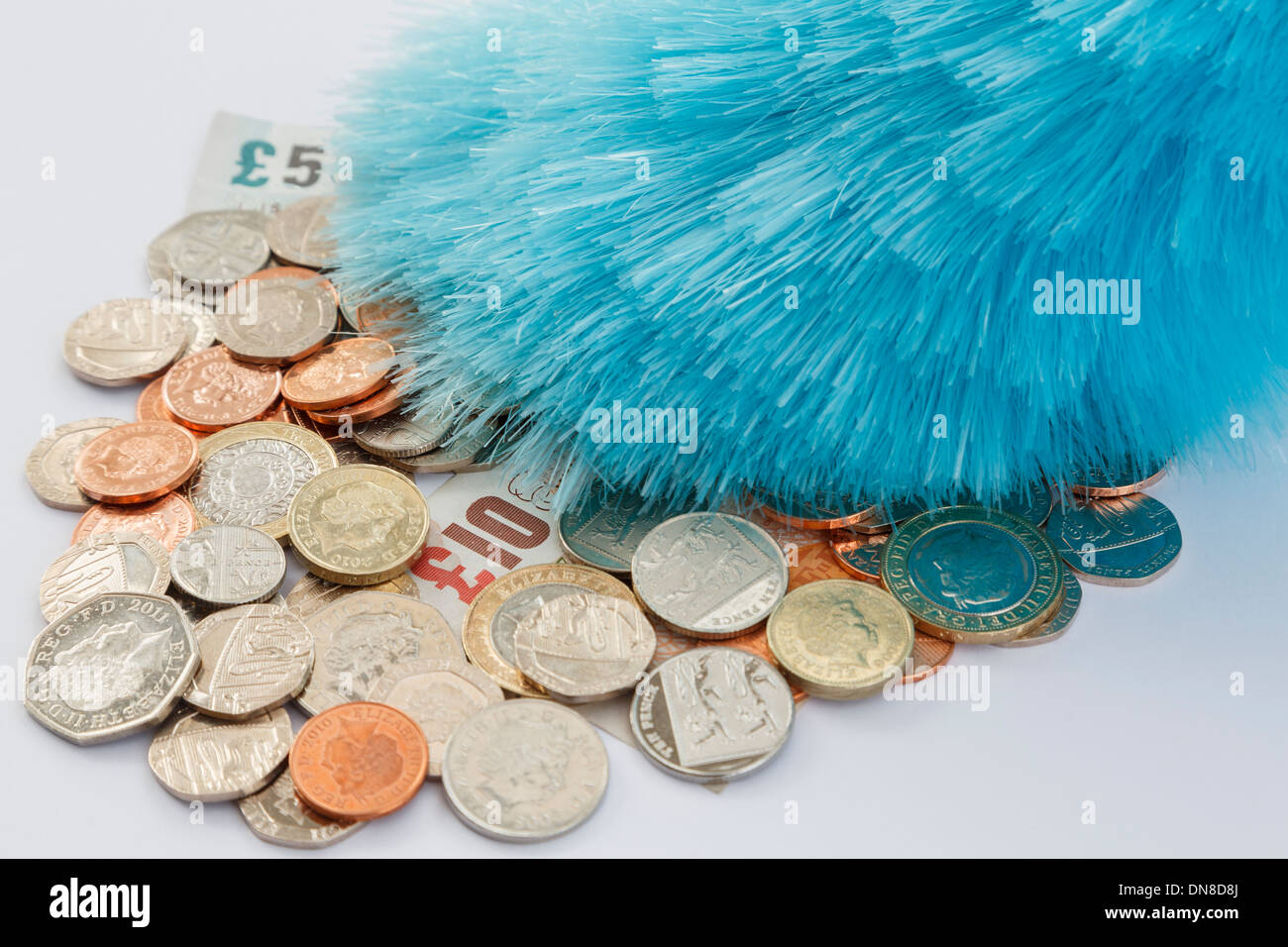 Un plumeau poussière une pile de pièces et billets de l'argent sterling. En Angleterre, Royaume-Uni, la Grande-Bretagne, l'Europe. Banque D'Images