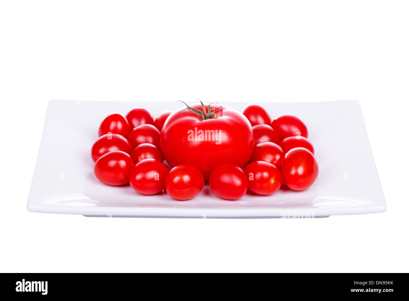 Tomates cerises fraîches sur la plaque isolé sur fond blanc Banque D'Images