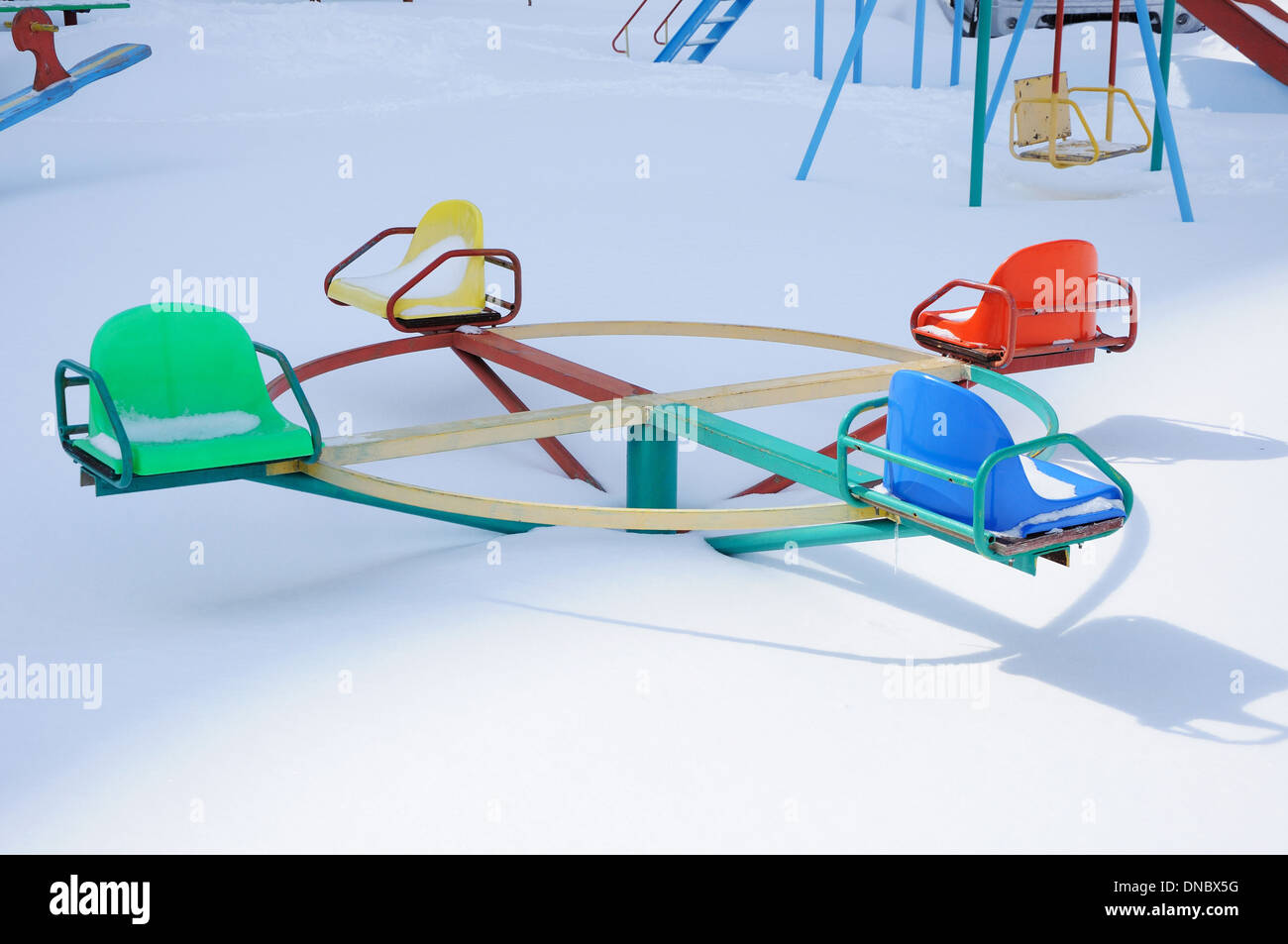 Merry-go-round sur l'aire de jeux sous la neige Banque D'Images