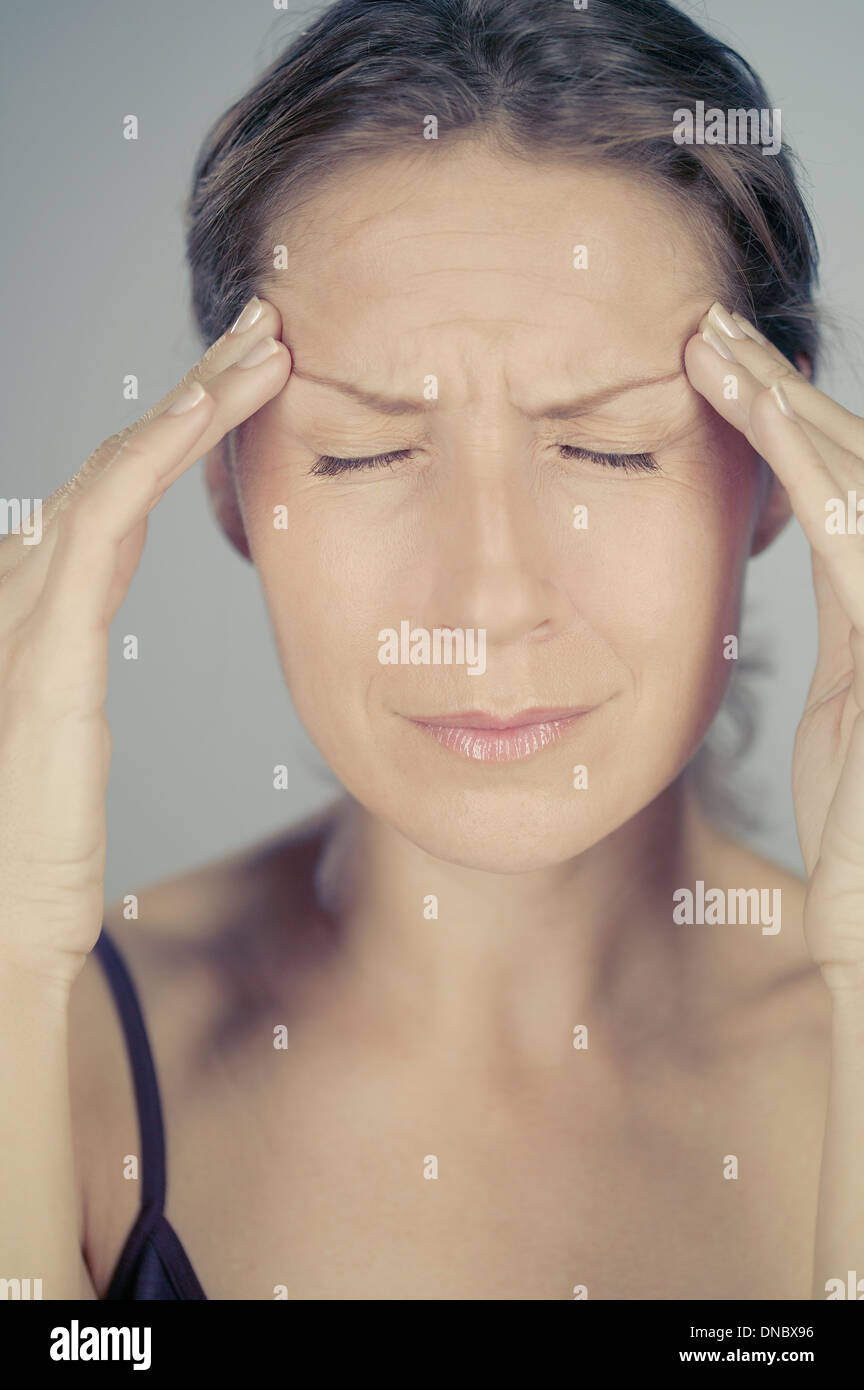 Une femme d'âge moyen avec un mal de tête Banque D'Images