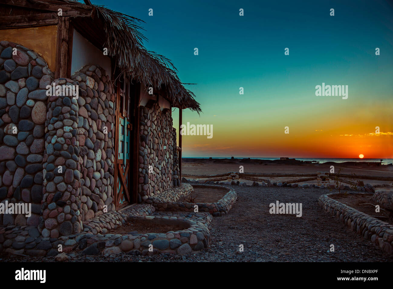 L'Egypte Marsa Alam coucher du soleil lever du soleil couleurs bleu jaune orange house mer océan soleil hut hut vieille porte shore beach rocks pierres du désert Banque D'Images