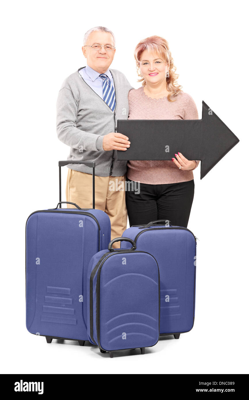 Full Length portrait of a smiling young les touristes détenteurs d'une grande flèche noire et sacs de voyage Banque D'Images