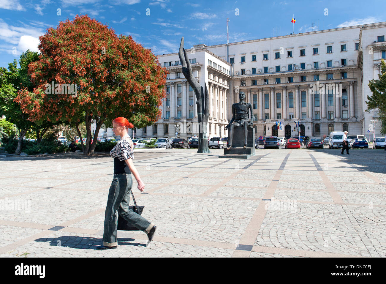 Femme marchant à travers la place de la révolution à Bucarest, la capitale de la Roumanie. Banque D'Images
