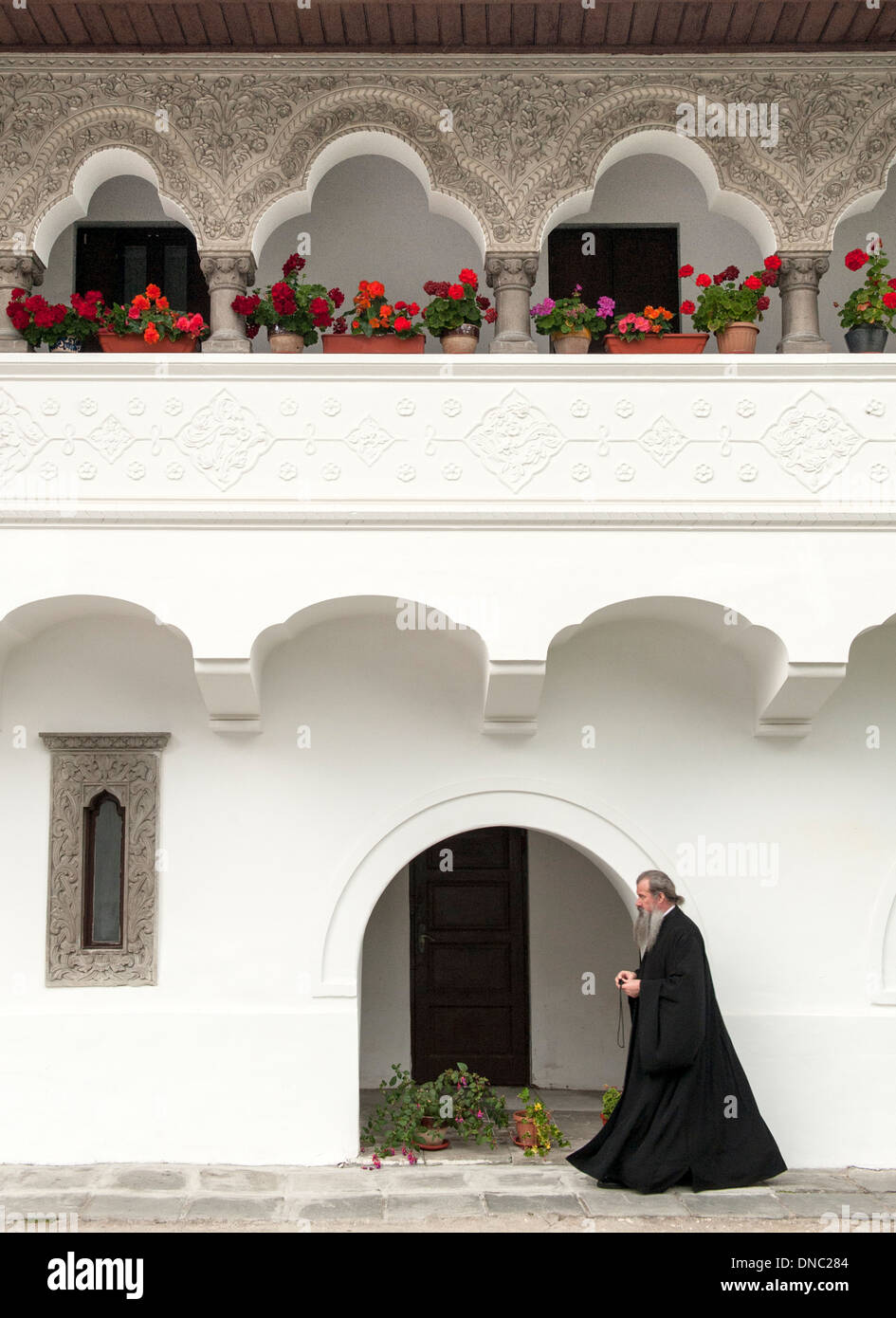 Un moine marchant dans la cour du monastère de Sinaia à Prahova comté dans la région de Transylvanie du centre de la Roumanie. Banque D'Images