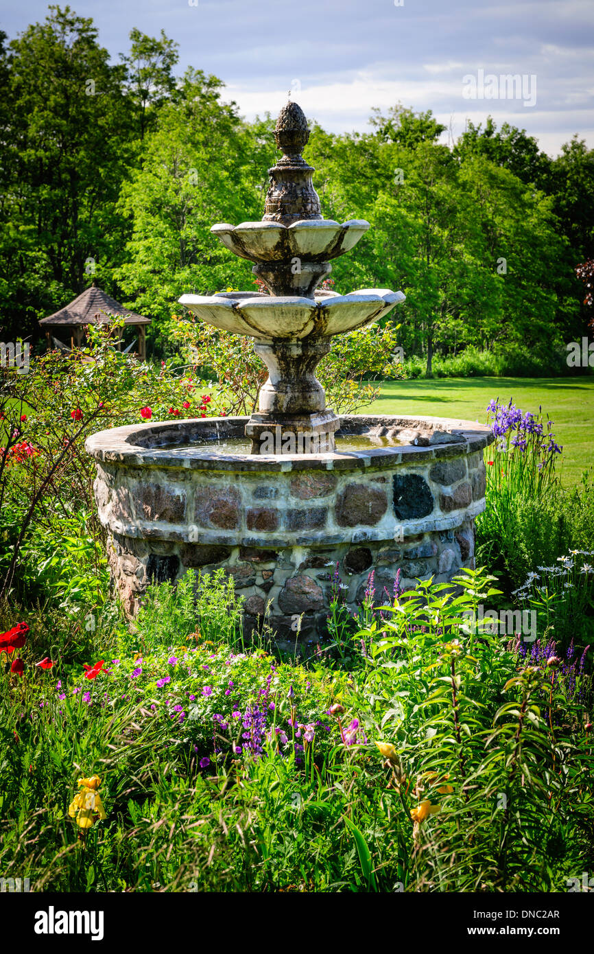 Jardin verdoyant avec des gradins fontaine en pierre Banque D'Images