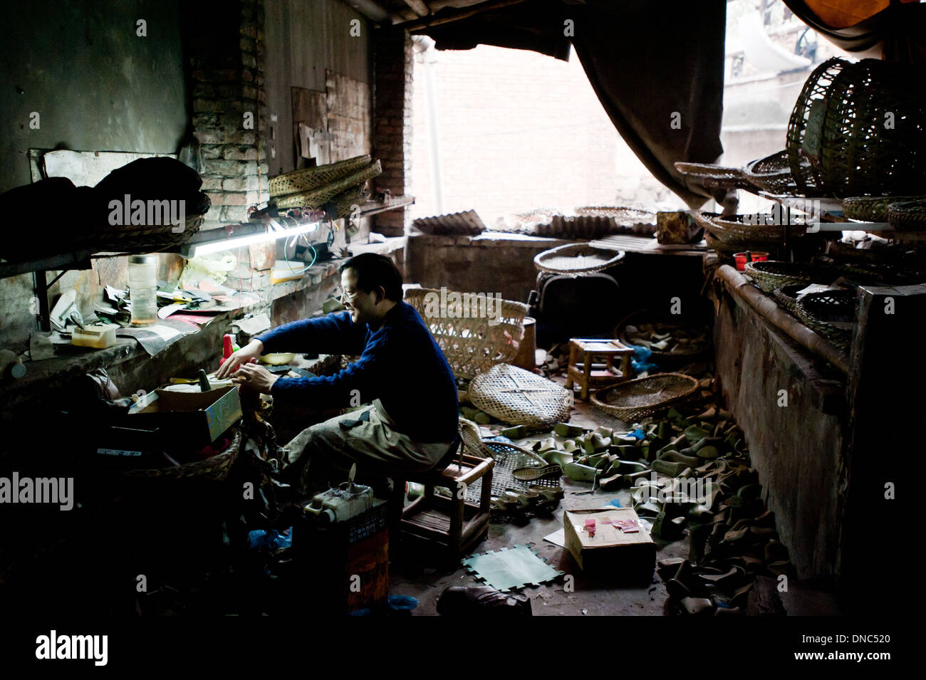 Chongqing, Chine - 31 décembre 2010 : un homme travaille dans une usine de chaussures. Banque D'Images