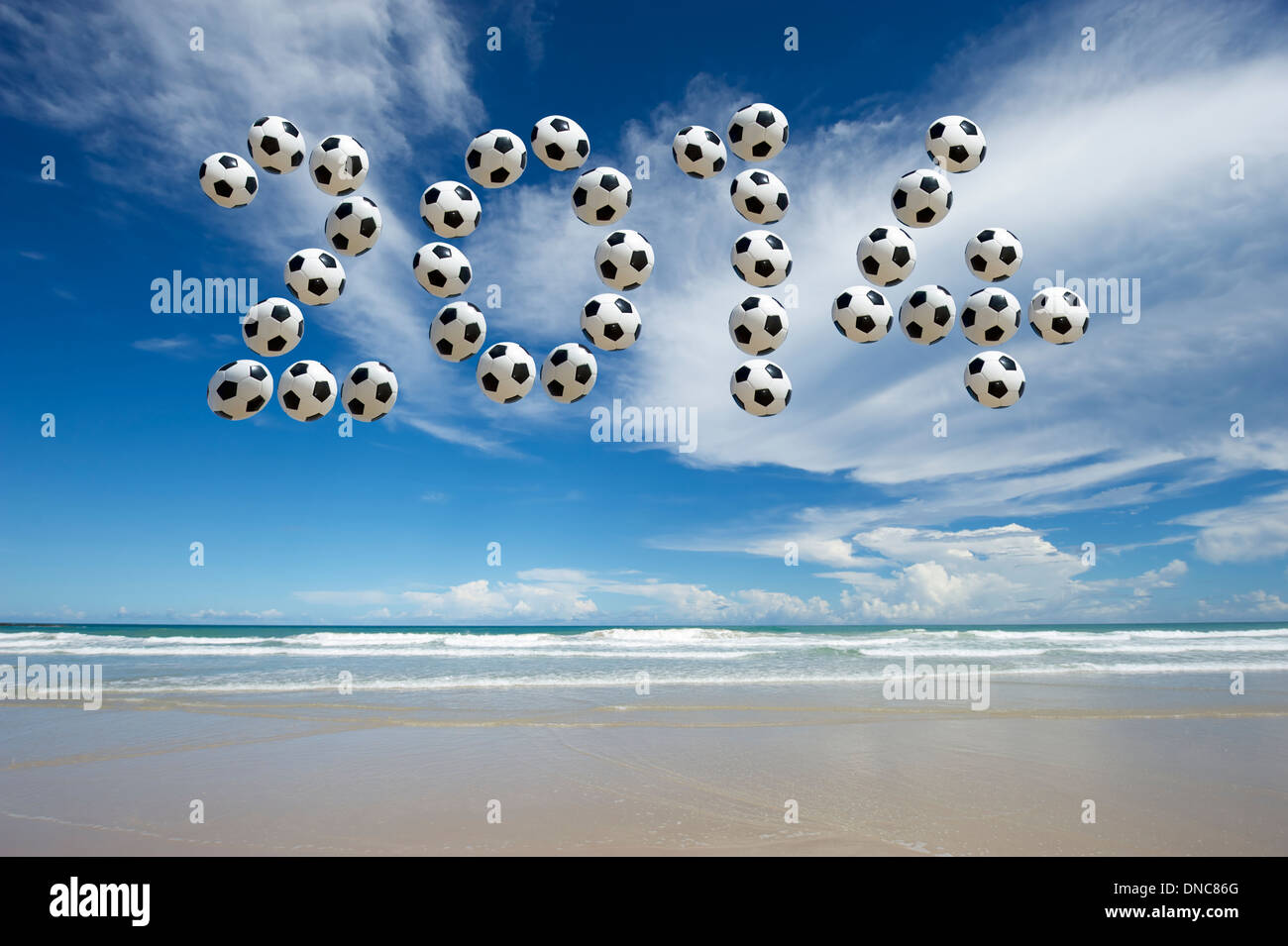 Nouvelle Année 2014 message faites avec des ballons de football dans le ciel sur une plage vide Banque D'Images