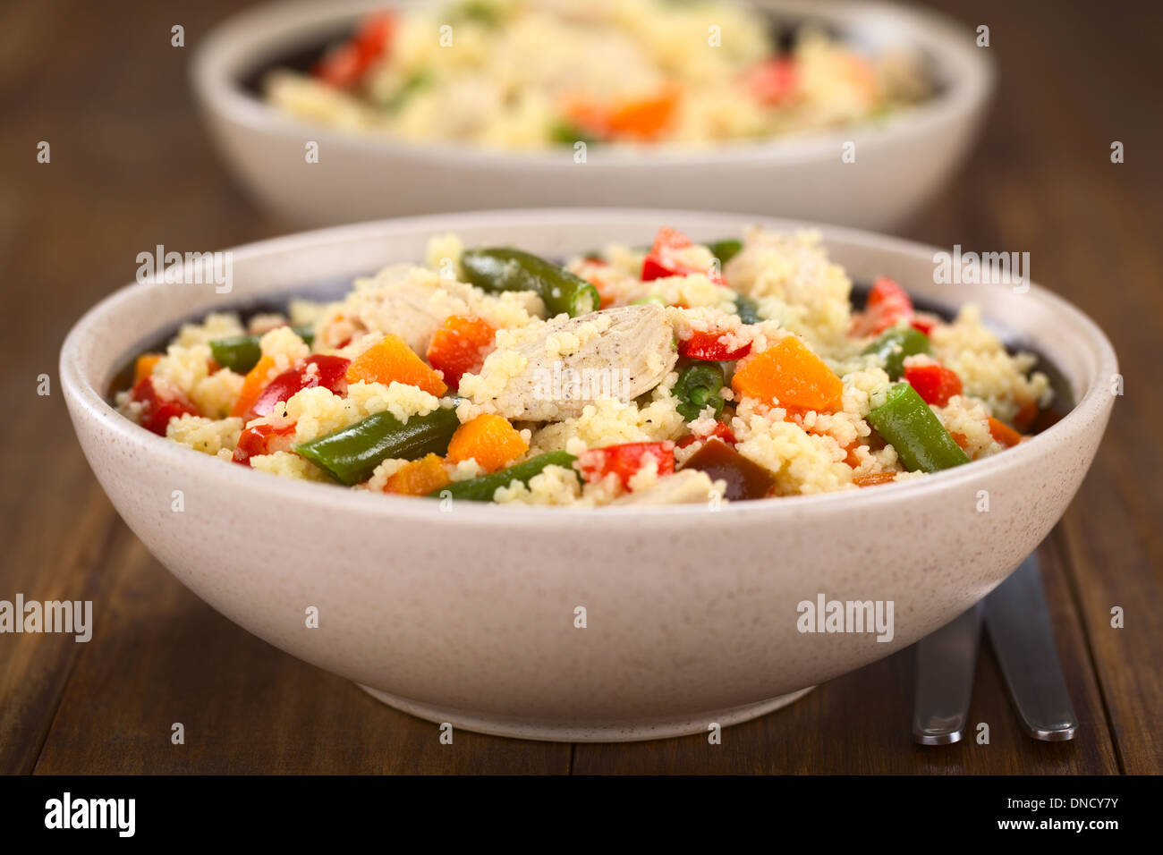 Deux bols de plat de couscous au poulet, haricot vert, carotte et poivron rouge Banque D'Images