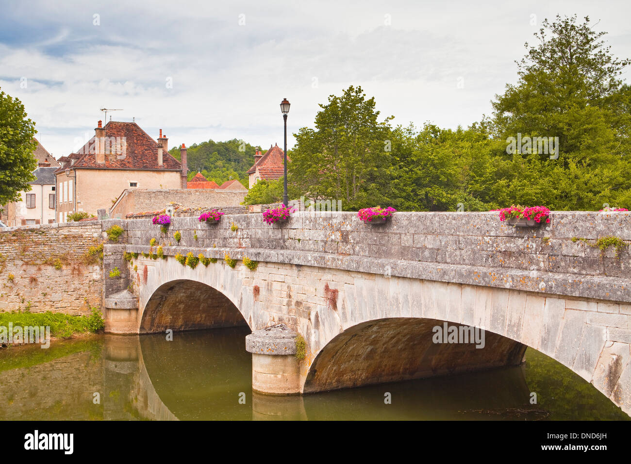 Un pont de pierre conduit au cours de la rivière serein au village de Noyers sur Serein en Bourgogne. Banque D'Images