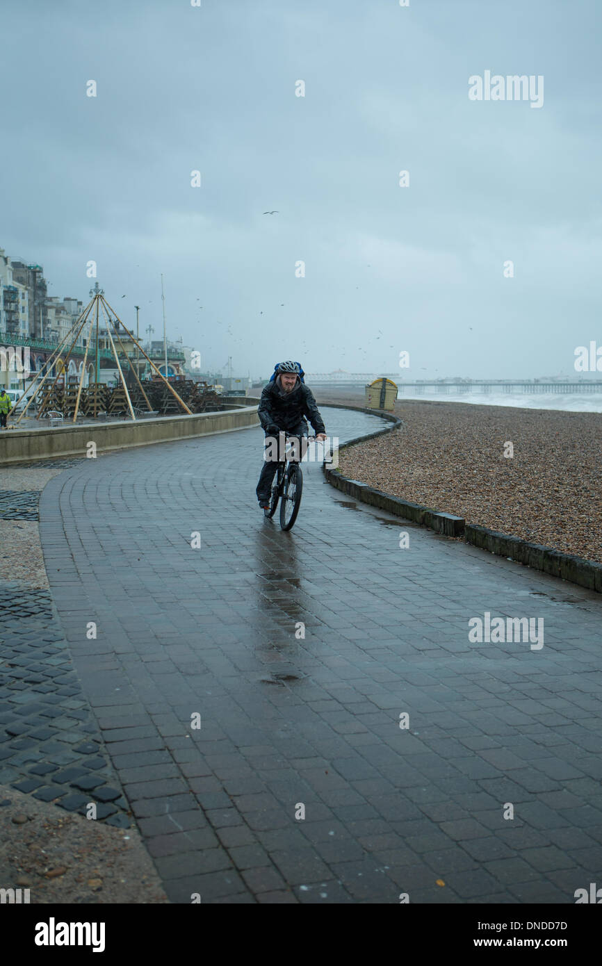 Aux prises avec des conditions météorologiques orageuses cycliste à la plage de Brighton, Brighton, East Sussex Royaume Uni le 23 décembre 2013. Banque D'Images