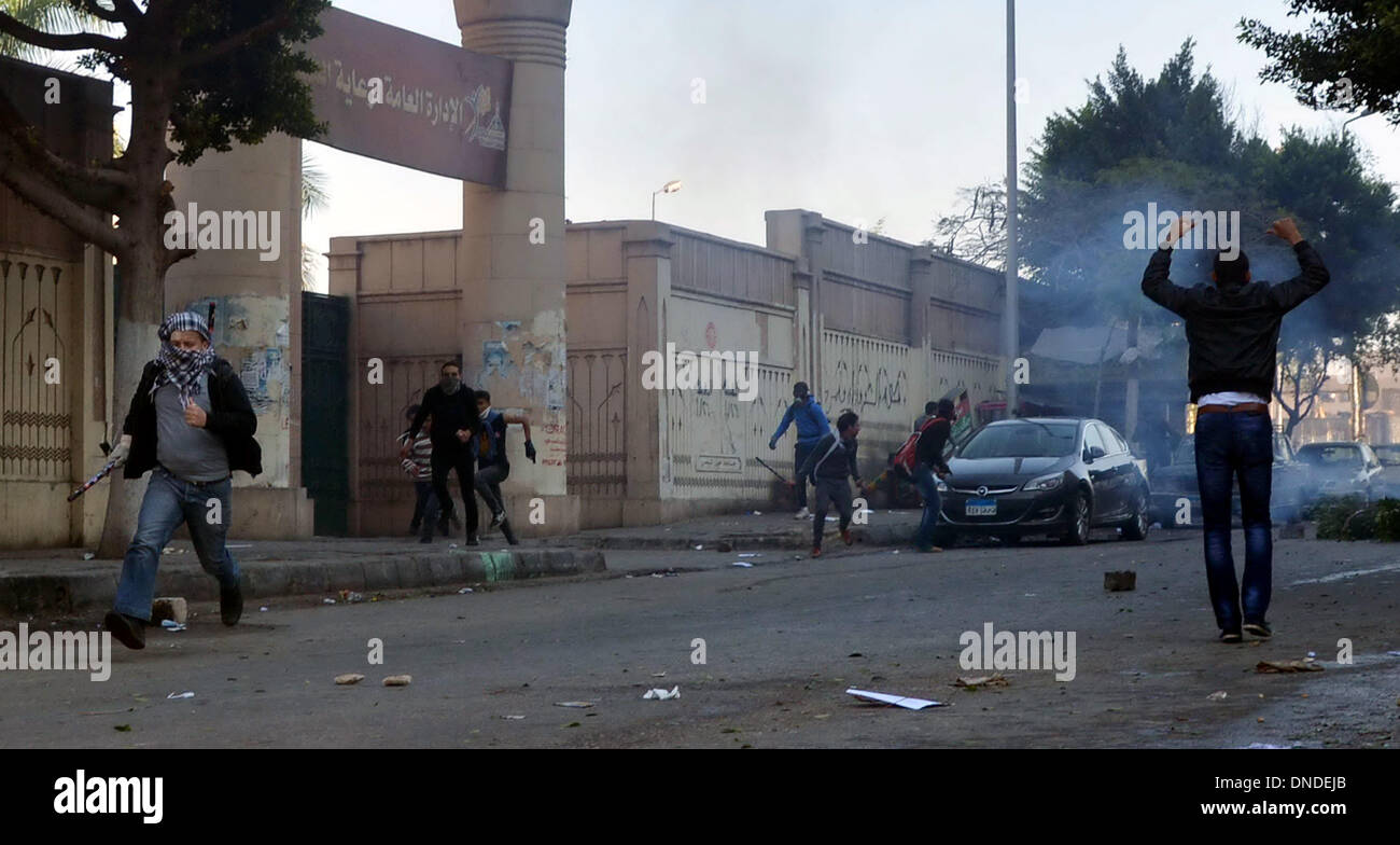 Le Caire, Le Caire, Égypte. Dec 23, 2013. Les étudiants de l'Université Ain Shams partisans des Frères musulmans et le président égyptien déchu Mohamed Morsi, réagissent comme des gaz lacrymogènes est tiré de forces de sécurité égyptiennes au cours d'affrontements au Caire le 23 décembre 2013 Crédit : Mohammed Bendari APA/Images/ZUMAPRESS.com/Alamy Live News Banque D'Images