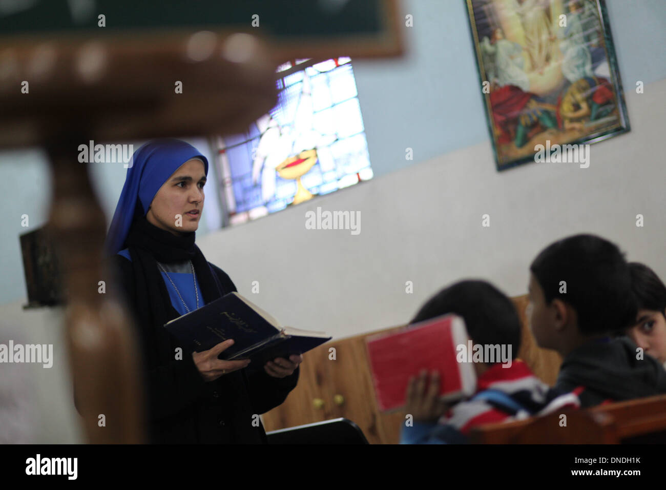 Gaza, Territoires palestiniens. Dec 23, 2013. Un brésilien nun enseigne les chrétiens palestiniens enfants le chant religieux à l'Église catholique dans la ville de Gaza pendant les préparatifs pour célébrer le jour de Noël le 23 décembre 2013.Photo : Ahmed Deeb/NurPhoto Crédit : Ahmed Deeb/NurPhoto ZUMAPRESS.com/Alamy/Live News Banque D'Images