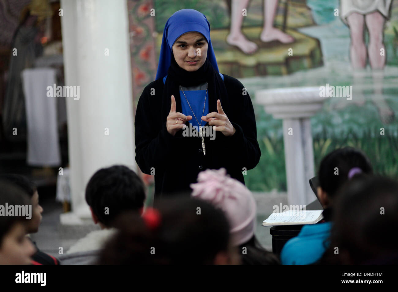 Gaza, Territoires palestiniens. Dec 23, 2013. Un brésilien nun enseigne les chrétiens palestiniens enfants le chant religieux à l'Église catholique dans la ville de Gaza pendant les préparatifs pour célébrer le jour de Noël le 23 décembre 2013.Photo : Ahmed Deeb/NurPhoto Crédit : Ahmed Deeb/NurPhoto ZUMAPRESS.com/Alamy/Live News Banque D'Images