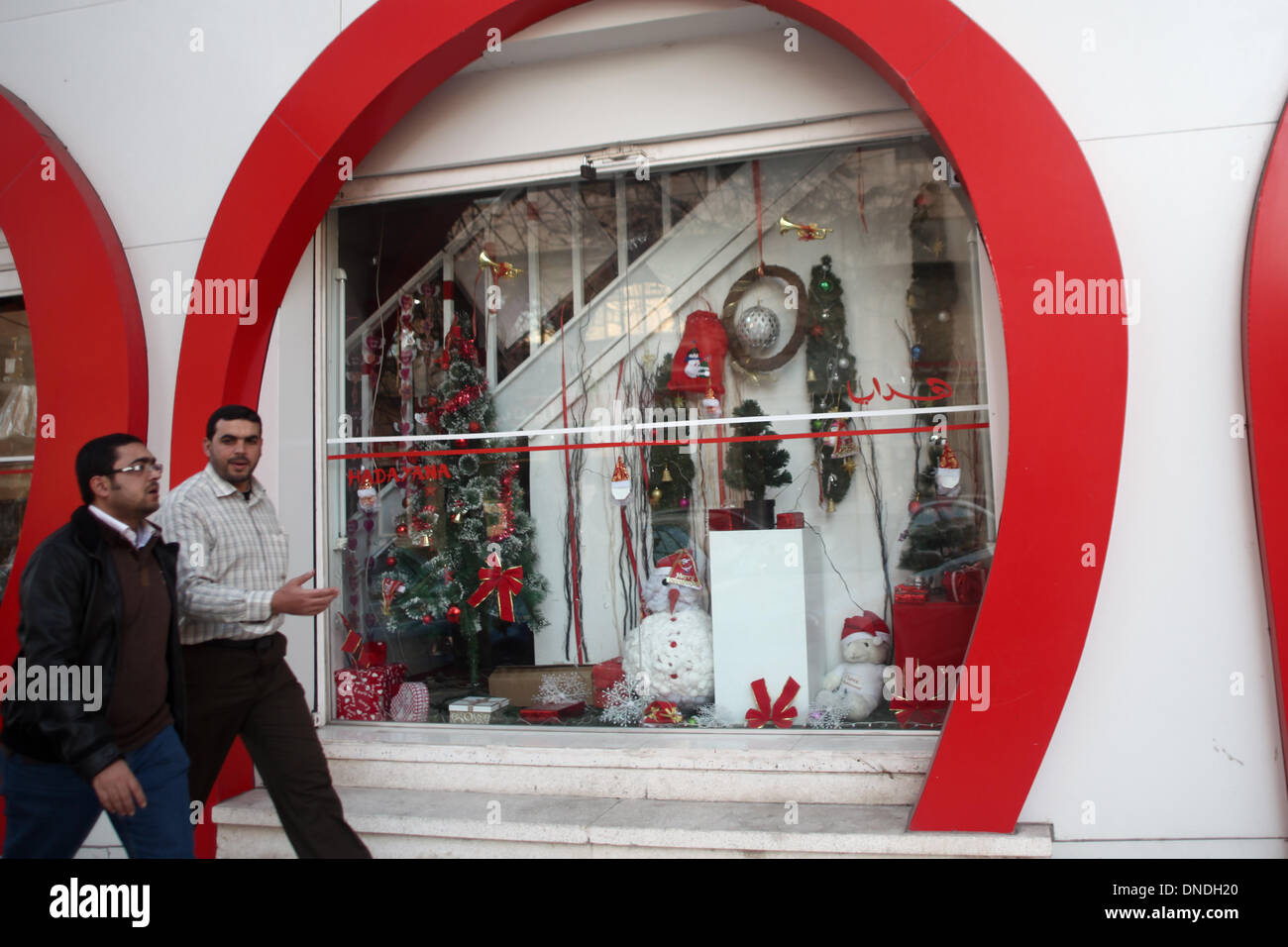 Gaza, Territoires palestiniens. Dec 23, 2013. Les Palestiniens passent devant un magasin décoré avec le Père Noël porte pendant les préparatifs avant Noël, dans la ville de Gaza, le 23 décembre 2013.Photo : Ahmed Deeb/NurPhoto Crédit : Ahmed Deeb/NurPhoto ZUMAPRESS.com/Alamy/Live News Banque D'Images