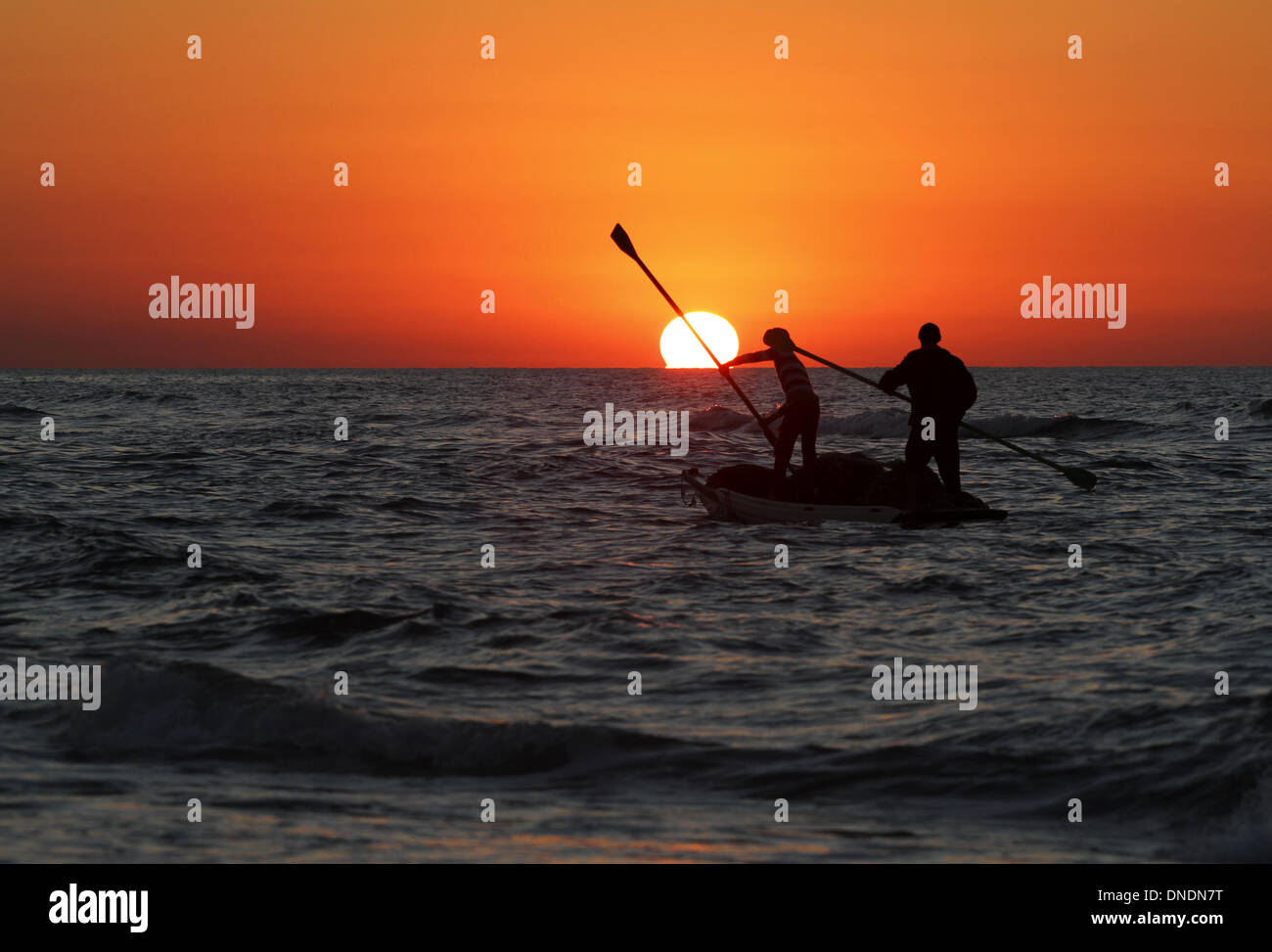 Gaza, Territoires palestiniens. Dec 23, 2013. Les pêcheurs palestiniens à prendre leur bateau sur la mer Méditerranée au coucher du soleil dans la ville de Gaza le 23 décembre 2013.Photo : Sameh Rahmi/NurPhoto Crédit : Sameh Rahmi/NurPhoto ZUMAPRESS.com/Alamy/Live News Banque D'Images