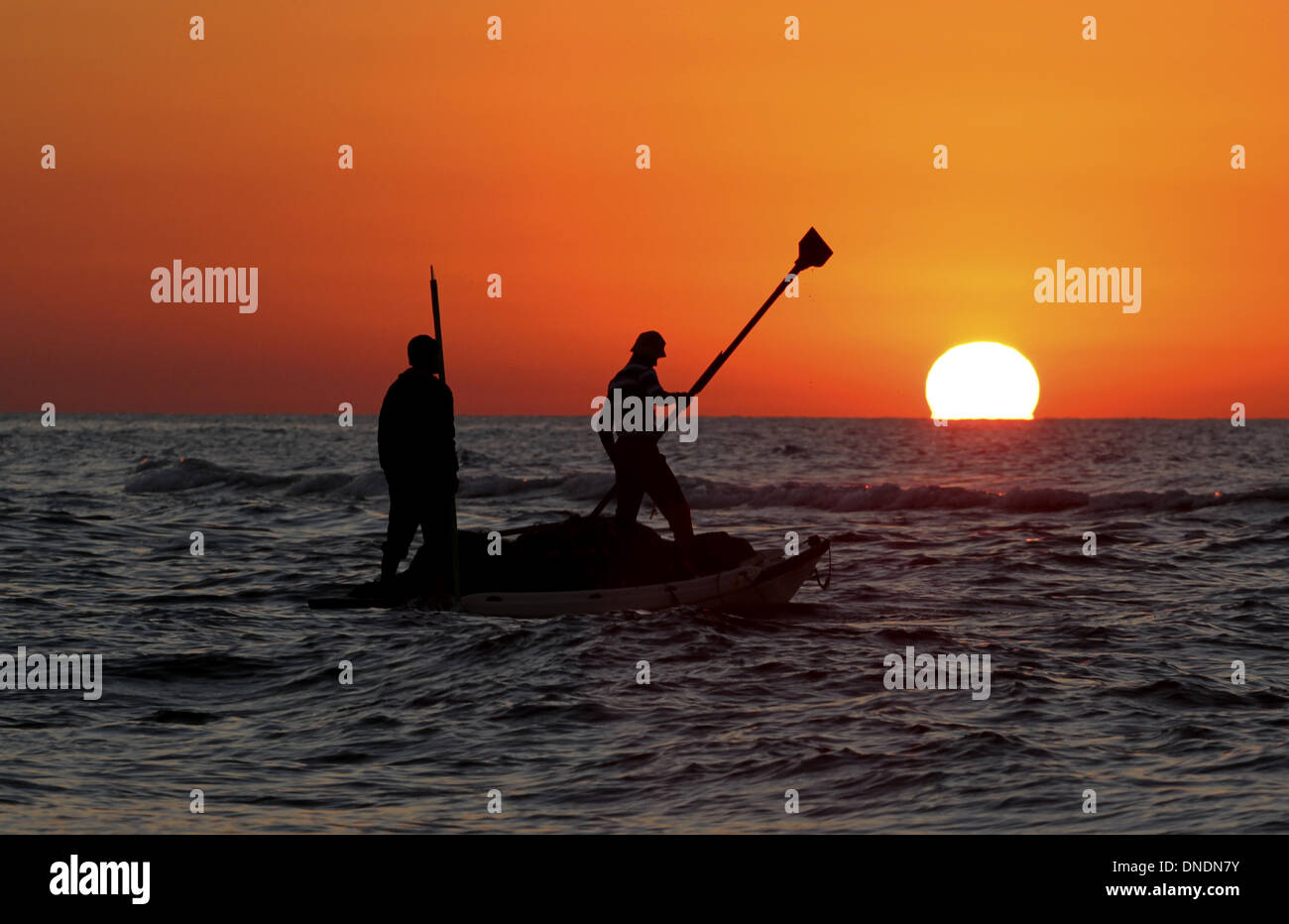 Gaza, Territoires palestiniens. Dec 23, 2013. Les pêcheurs palestiniens à prendre leur bateau sur la mer Méditerranée au coucher du soleil dans la ville de Gaza le 23 décembre 2013.Photo : Sameh Rahmi/NurPhoto Crédit : Sameh Rahmi/NurPhoto ZUMAPRESS.com/Alamy/Live News Banque D'Images