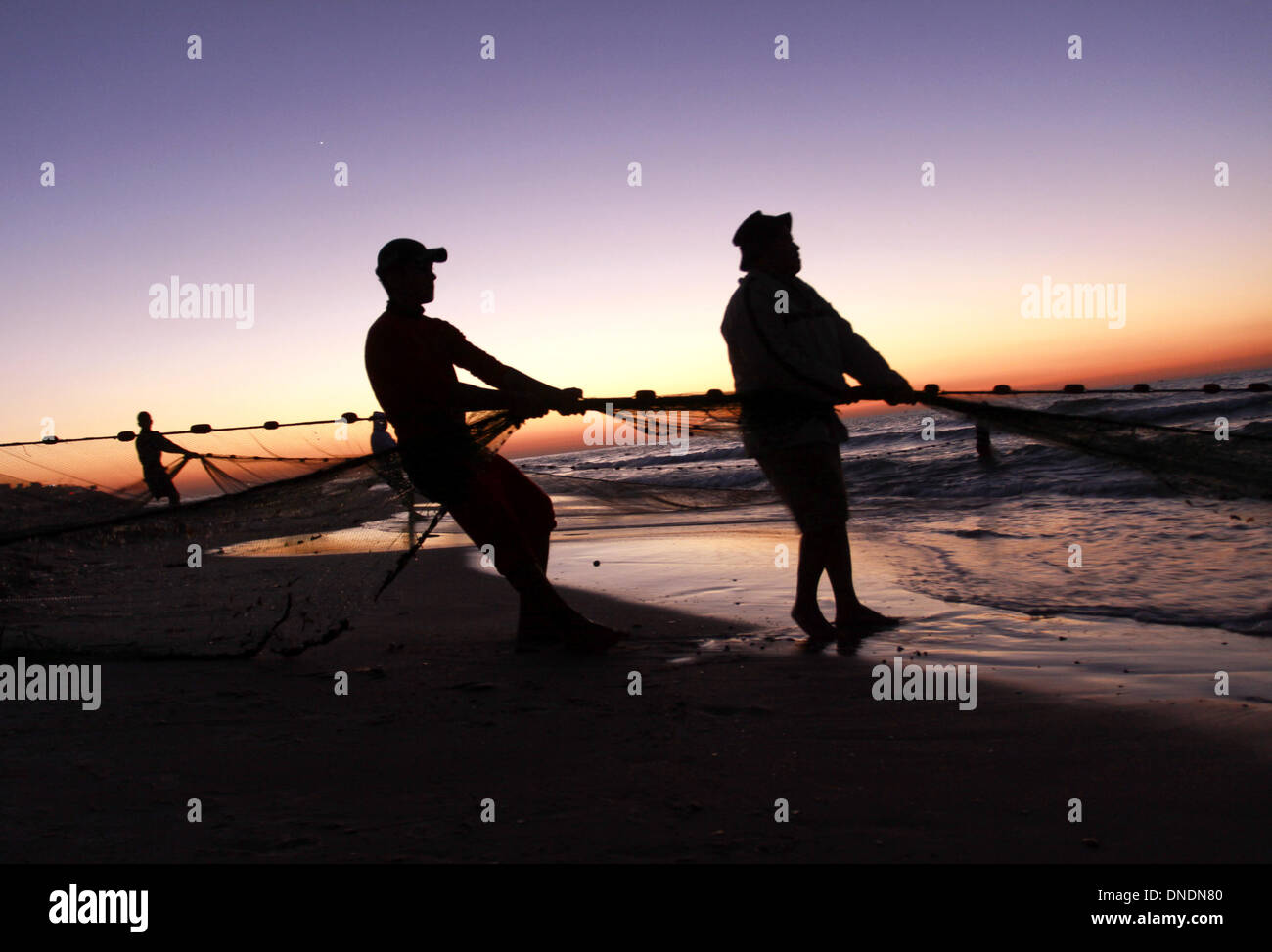 Gaza, Territoires palestiniens. Dec 23, 2013. Les pêcheurs palestiniens tirer leurs filets de la mer Méditerranée au coucher du soleil dans la ville de Gaza le 23 décembre 2013.Photo : Sameh Rahmi/NurPhoto Crédit : Sameh Rahmi/NurPhoto ZUMAPRESS.com/Alamy/Live News Banque D'Images