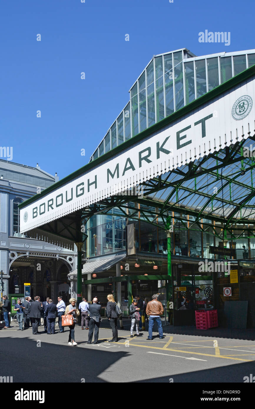 Les gens à l'extérieur du célèbre Borough Market signe et entrée vend principalement des aliments de spécialité au grand public ensoleillé Southwark Londres Angleterre Royaume-Uni Banque D'Images