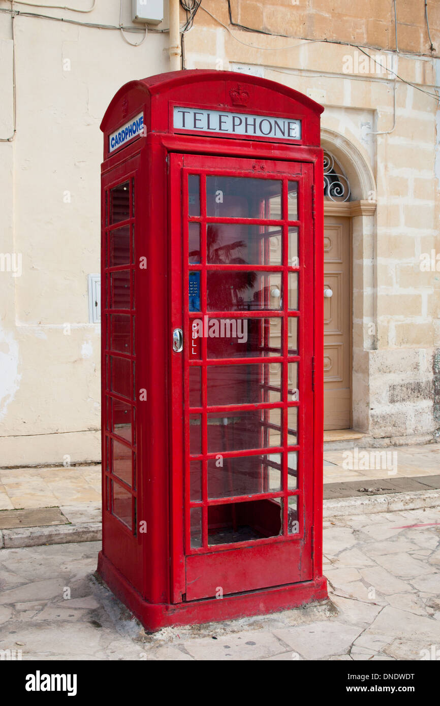 Une cabine téléphonique rouge à Marsaxlokk, Malte. Banque D'Images