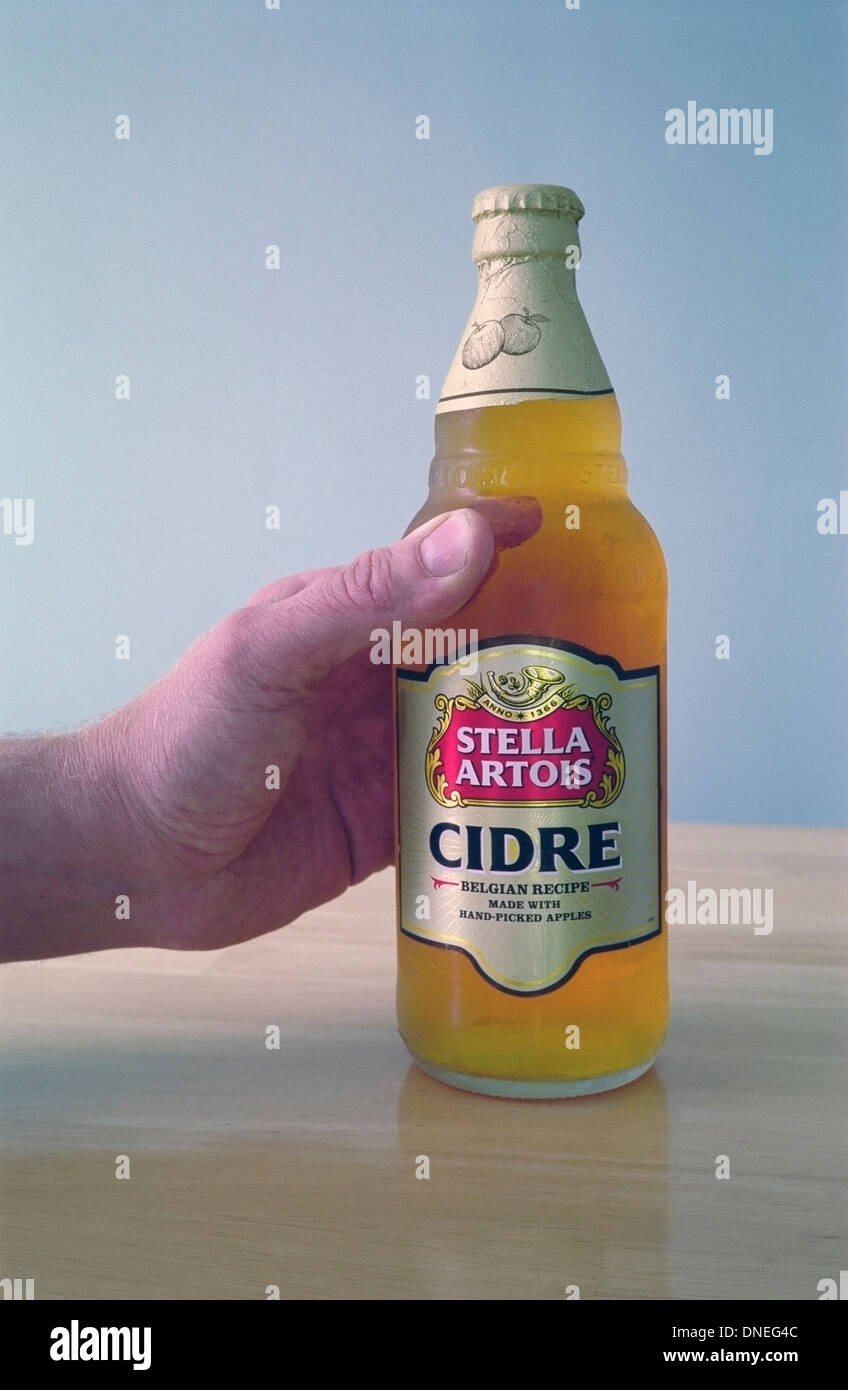 Man's Hand Holding une bouteille de Stella Artois Cidre PARUTION MODÈLE Banque D'Images