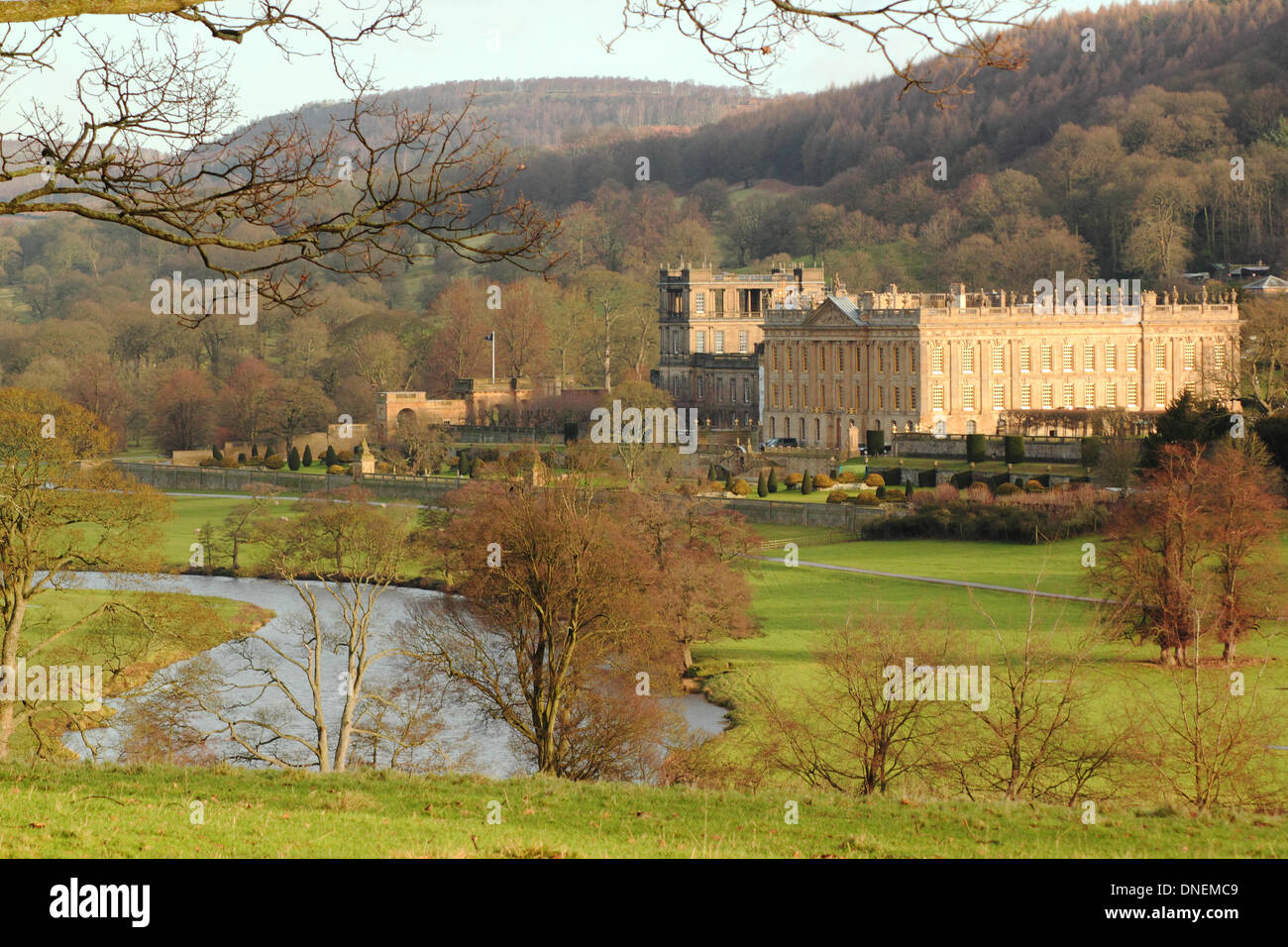 Recueillir des daims par le parc à Chatsworth House contre un gonflement du fleuve Derwent après les fortes pluies de l'hiver, parc national de Peak District, Derbyshire, Angleterre, RU Banque D'Images
