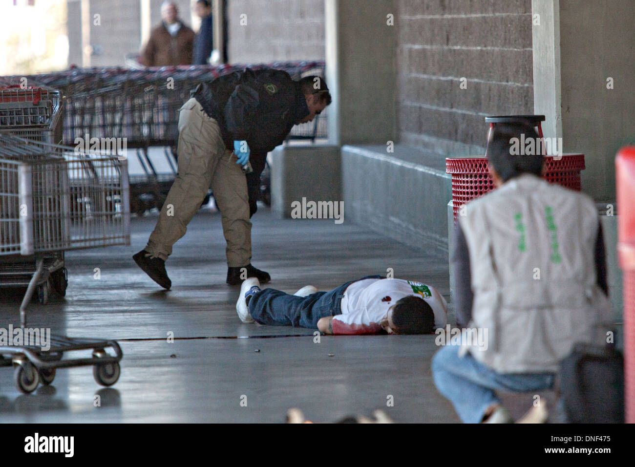 Voir les enquêteurs la scène du crime d'un médicament sur l'exécution à la magasin Costco le 15 janvier 2009 à Juarez, au Mexique. Le tournage, liée à la drogue en cours à une guerre qui a déjà fait plus de 40 personnes depuis le début de l'année. Plus de 1600 personnes ont été tuées à Juarez en 2008, faisant de la ville la plus violente Juarez au Mexique. Banque D'Images
