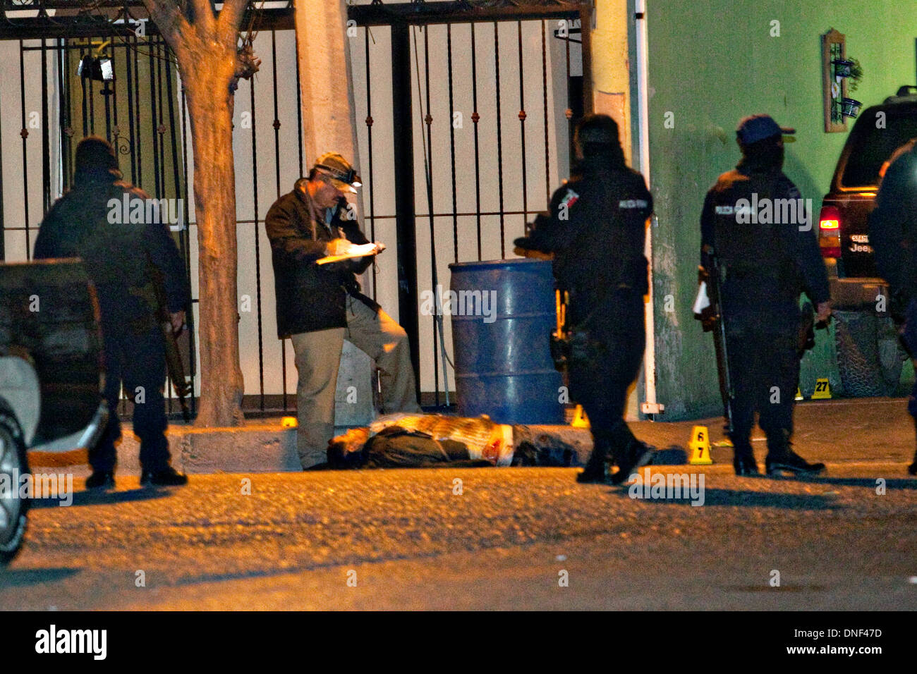 Un enquêteur de police examine le corps d'un homme tué par cartel assassins comme il est allé rendre visite à sa famille le 14 janvier 2009 à Juarez, au Mexique. Le tournage, liée à la drogue en cours à une guerre qui a déjà fait plus de 40 personnes depuis le début de l'année. Plus de 1600 personnes ont été tuées à Juarez en 2008, faisant de la ville la plus violente Juarez au Mexique. Banque D'Images