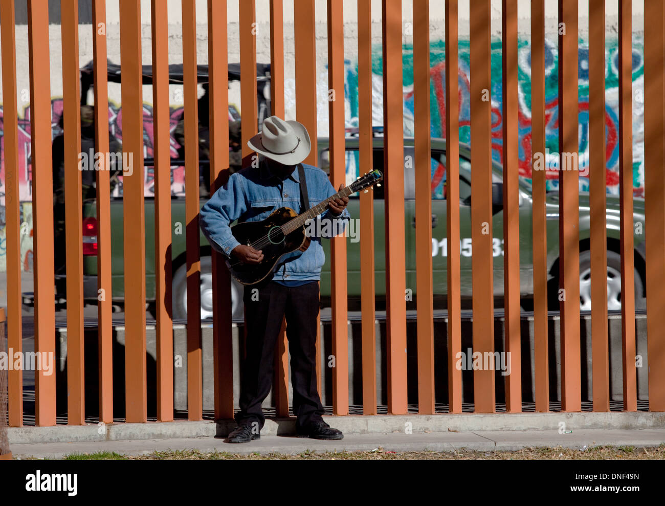 Un joueur de guitare pratiques dans le parc Benito Juarez comme une patrouille de l'armée mexicaine des lecteurs 17 Janvier, 2009 à Juarez, au Mexique. Les patrouilles militaires lourdement armés, la ville d'aider à endiguer la violence dans le cadre de la guerre contre la drogue qui a déjà fait plus de 40 personnes depuis le début de l'année. Plus de 1600 personnes ont été tuées à Juarez en 2008, faisant de la ville la plus violente Juarez au Mexique. Banque D'Images