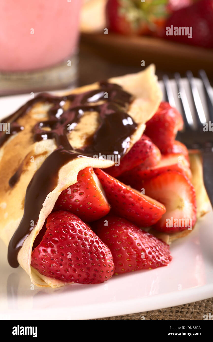 La crêpe remplie de fraises fraîches et sauce au chocolat sur le dessus (Selective Focus, Focus sur la fraise à l'avant) Banque D'Images