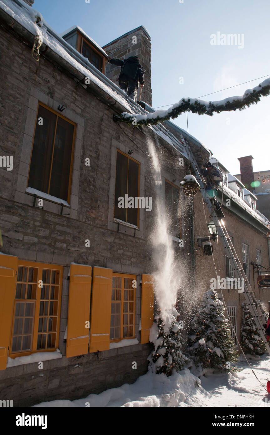 Un homme l'élimination d'un toit de neige dans la ville de Québec Banque D'Images