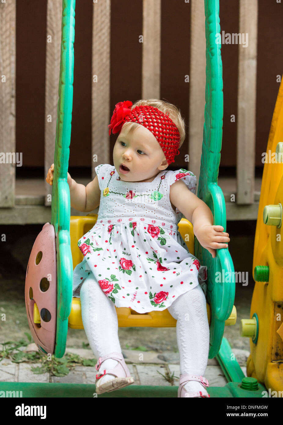 Ans enfant adorable petite fille assise sur une balançoire à l'été, Almaty, Kazakhstan Banque D'Images