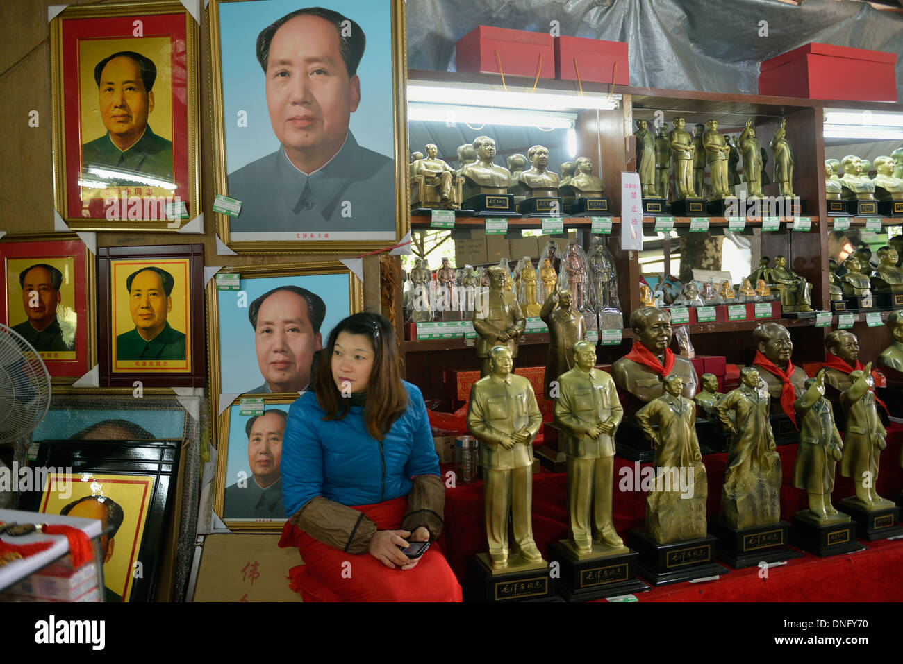 Une femme vend des souvenirs de Mao Zedong, Shaoshan dans la maison natale de Mao, dans la province de Hunan, en Chine. 06-Déc-2013 Banque D'Images