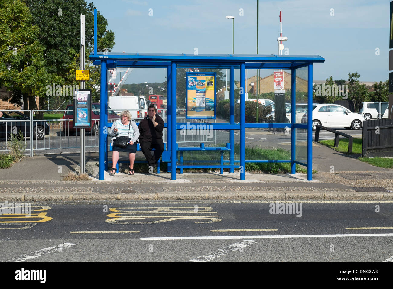 2 personnes en attente d'un arrêt de bus Banque D'Images