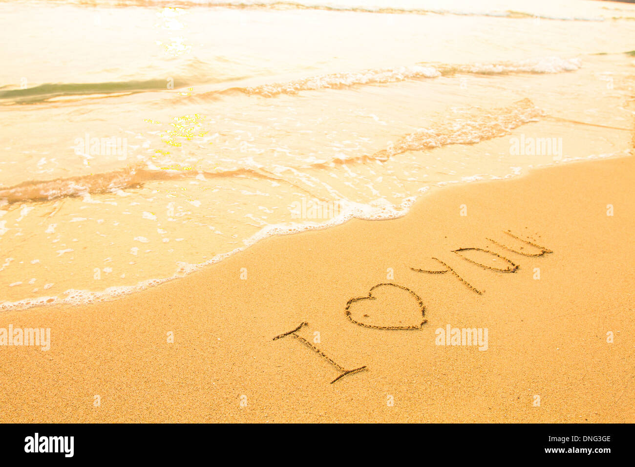 Je vous aime - inscription sur la plage de sable, soft surf wave. Banque D'Images